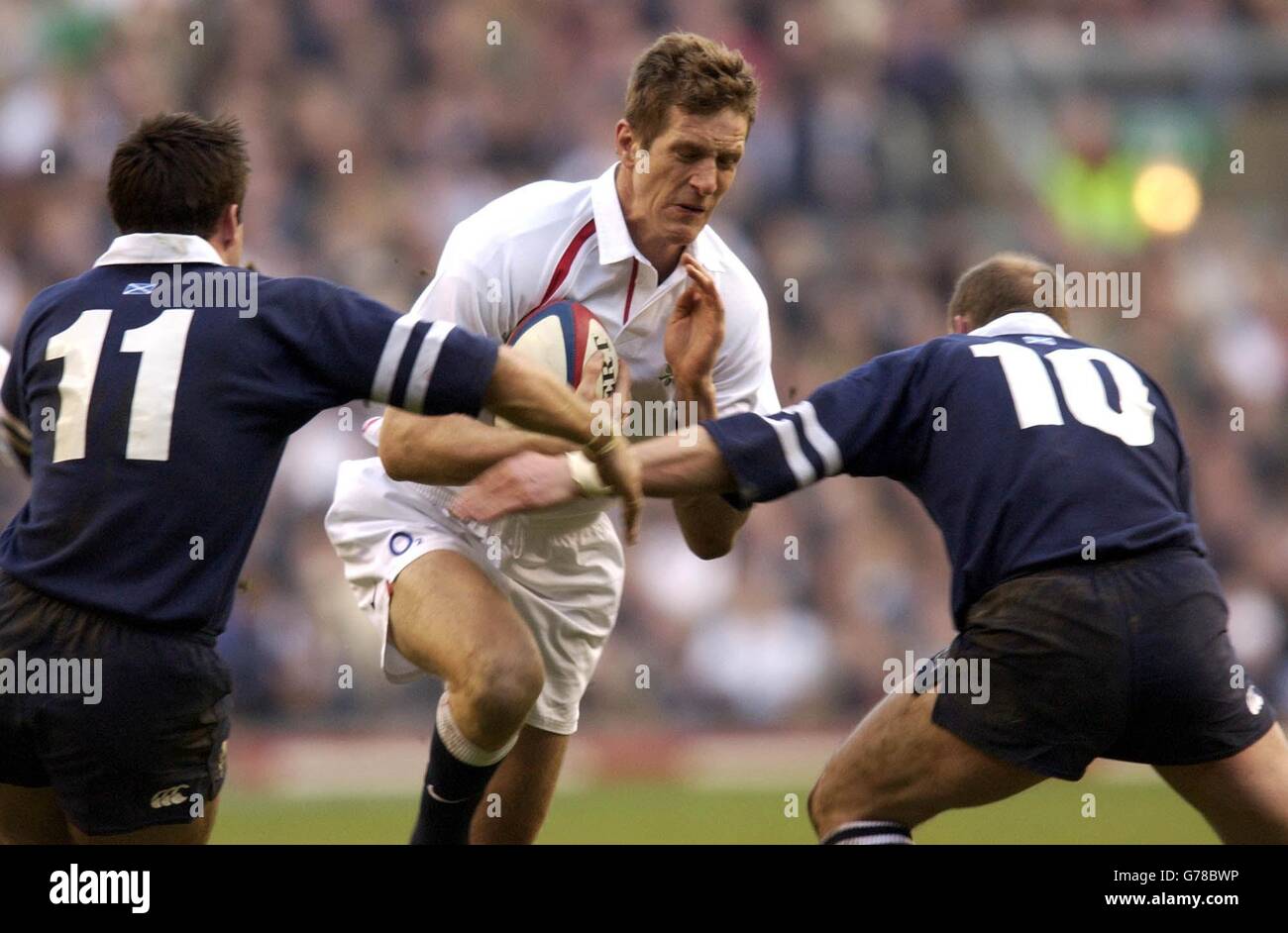 England's Will Greenwood (centre) breaks past Scotland's Kenny Logan (left) and Gregor Townsend during the RBS 6 Nations match against Scotland at Twickenham, London. England defeated Scotland 40-9. Stock Photo