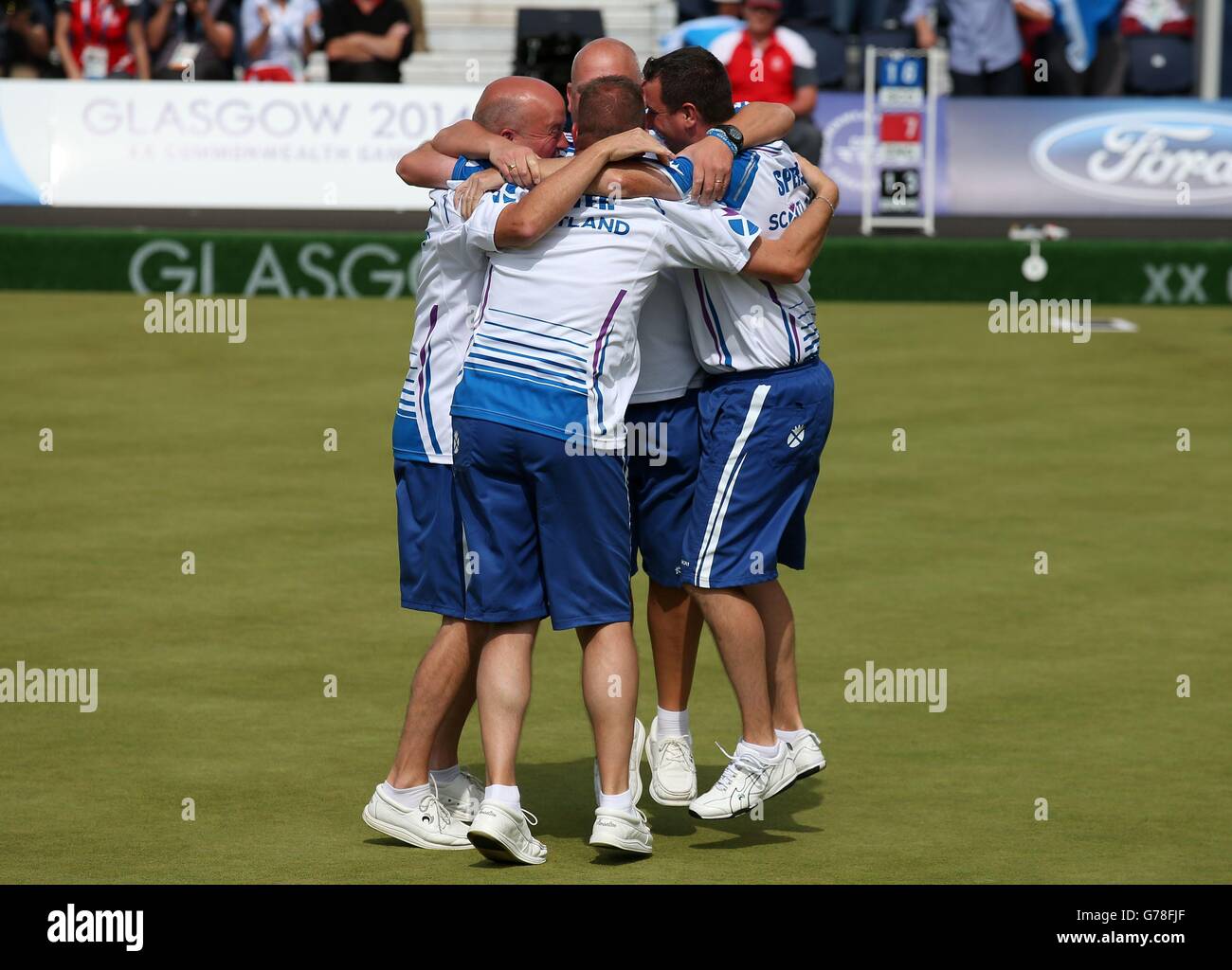 Scotland's Alex Marshall,Paul Foster, Neil Speirs and David Peacock hug after winning against England in the Men's Fours final at Kelvingrove Lawn Bowls Centre, during the 2014 Commonwealth Games in Glasgow. Stock Photo