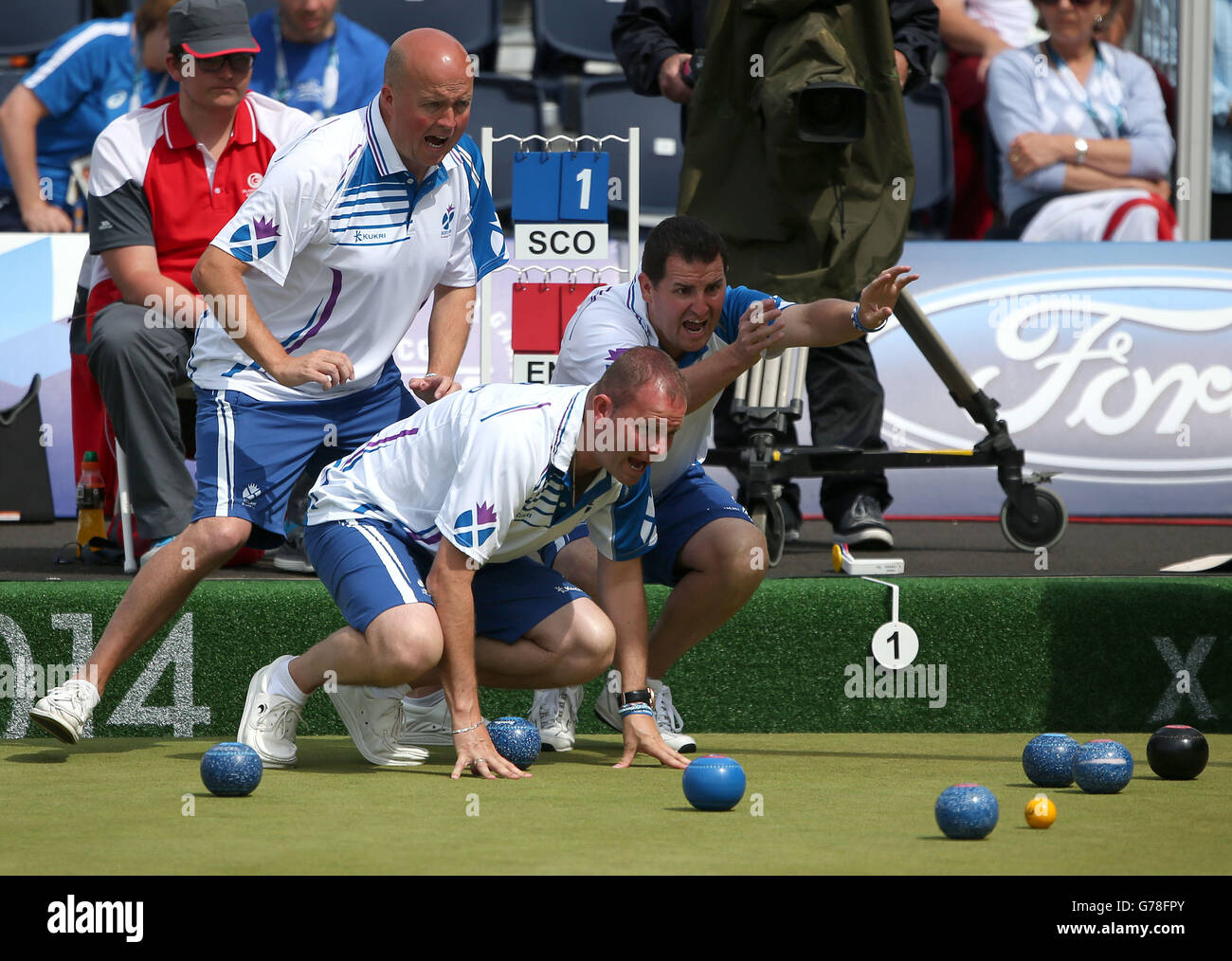 Scotland's Paul Foster, Neil Speirs and David Peacock shout at a bowl against England in the Men's Fours final at Kelvingrove Lawn Bowls Centre, during the 2014 Commonwealth Games in Glasgow. Stock Photo