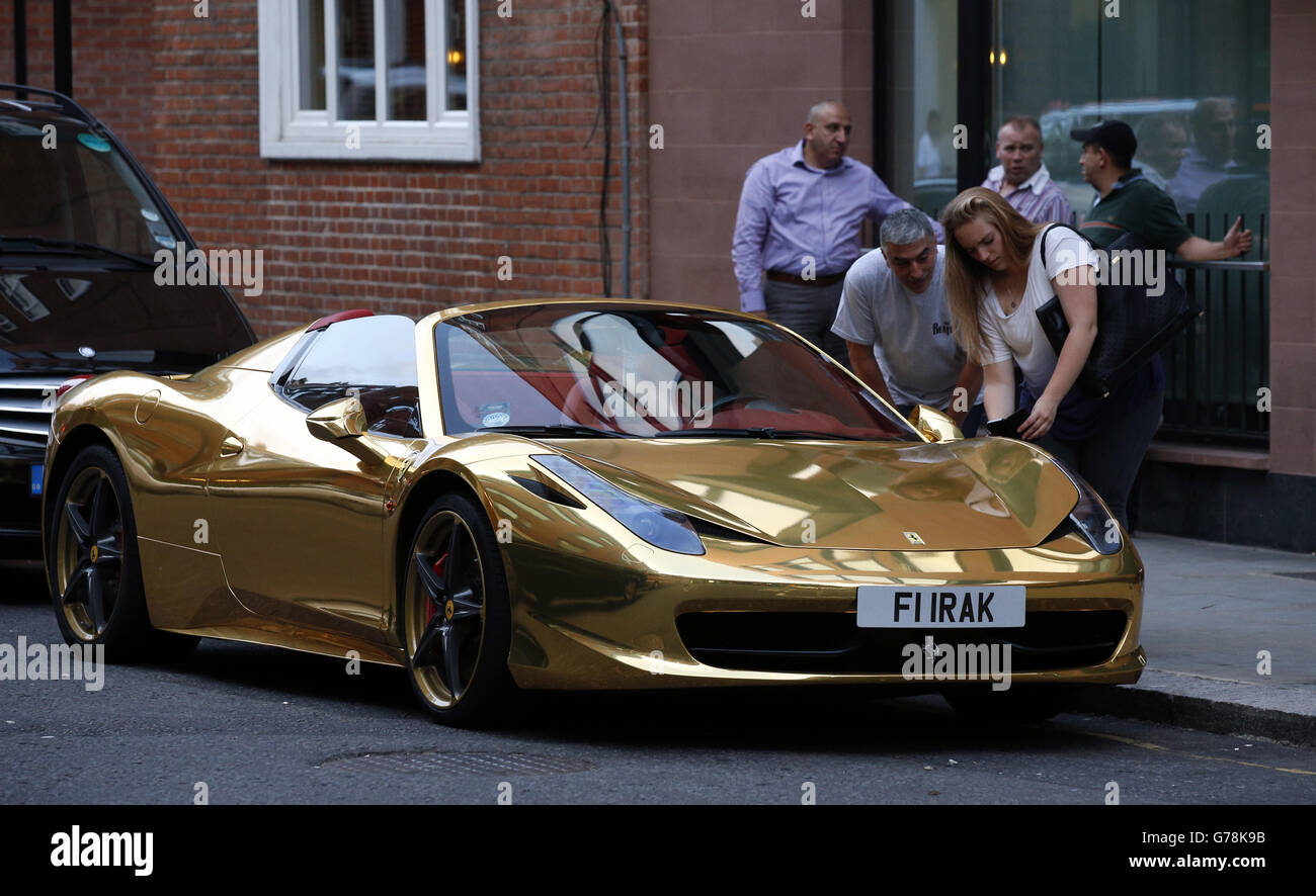 Passers-by photograph a golden coloured Ferrari parked outside Harrods department store, Knightsbridge. Stock Photo