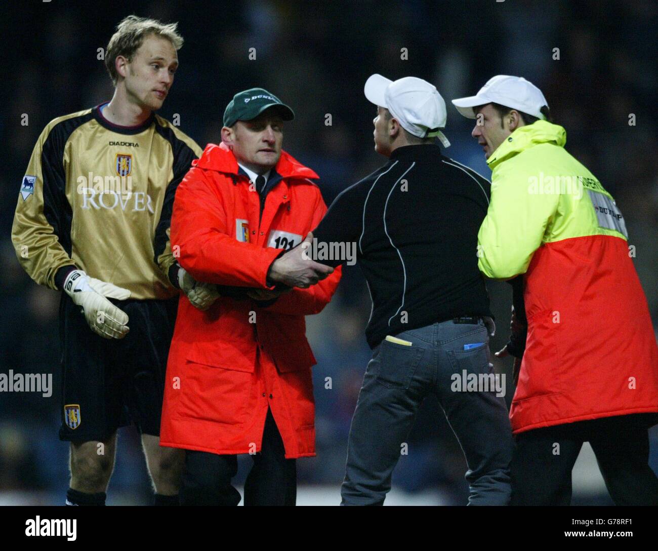 Aston Villa keeper Peter Enckelman looks at Aston Villa fan who ran from Holte End to shout at Birmingham City's Robbie Savage during their FA Barclaycard Premiership game at Villa Park, Birmingham. Stock Photo