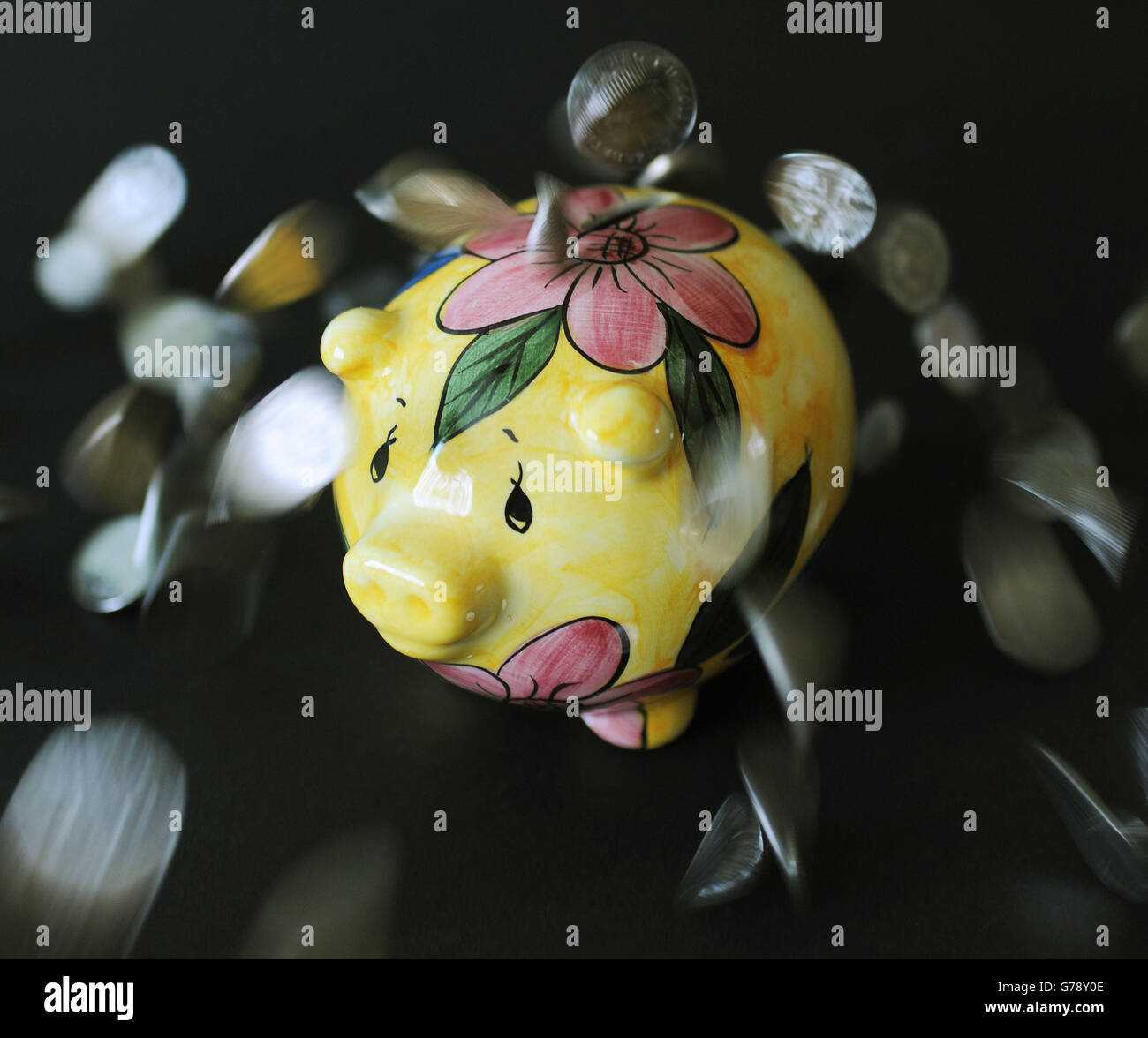 Pocket money, stock. Coins are dropped onto a piggy bank. Stock Photo
