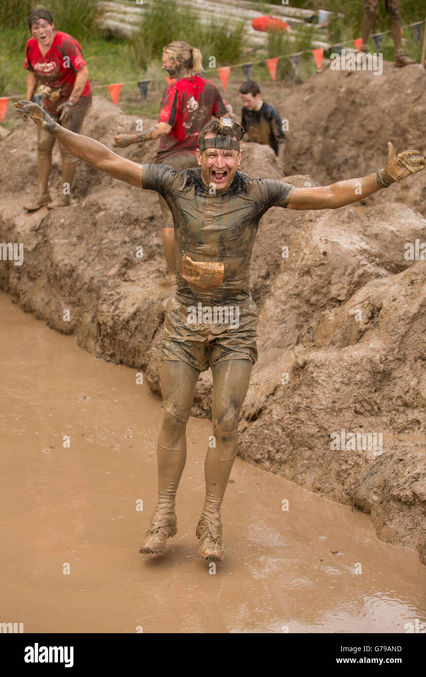 Man taking mud bath on the the Mud Mile obstacle at Tough Mudder at Drumlanrig Castle, Dumfries and Galloway, Scotland, UK. 26th June, 2016. Stock Photo