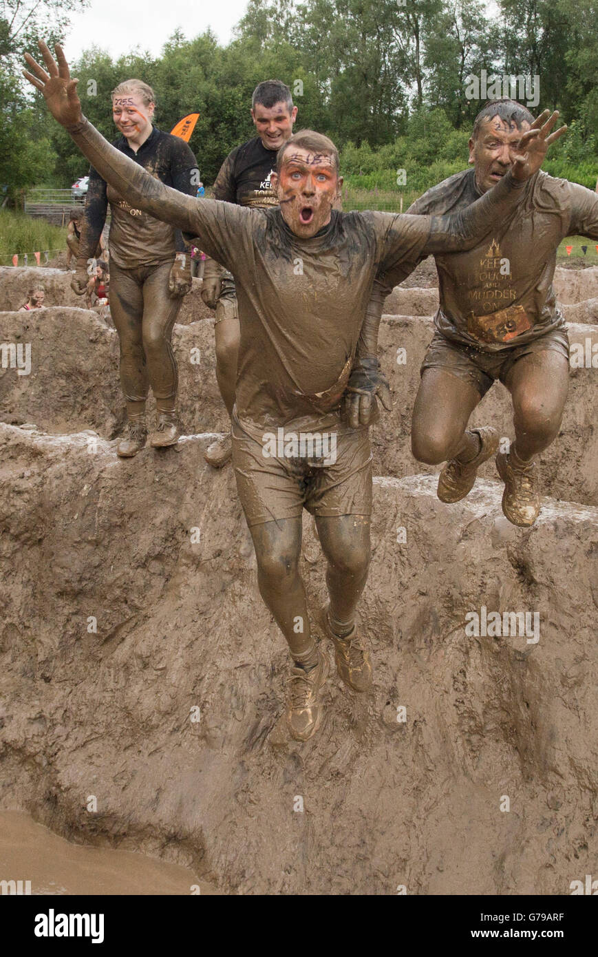 Tough Mudder mucky mad men jumping into muddy bath on the Mud Mile