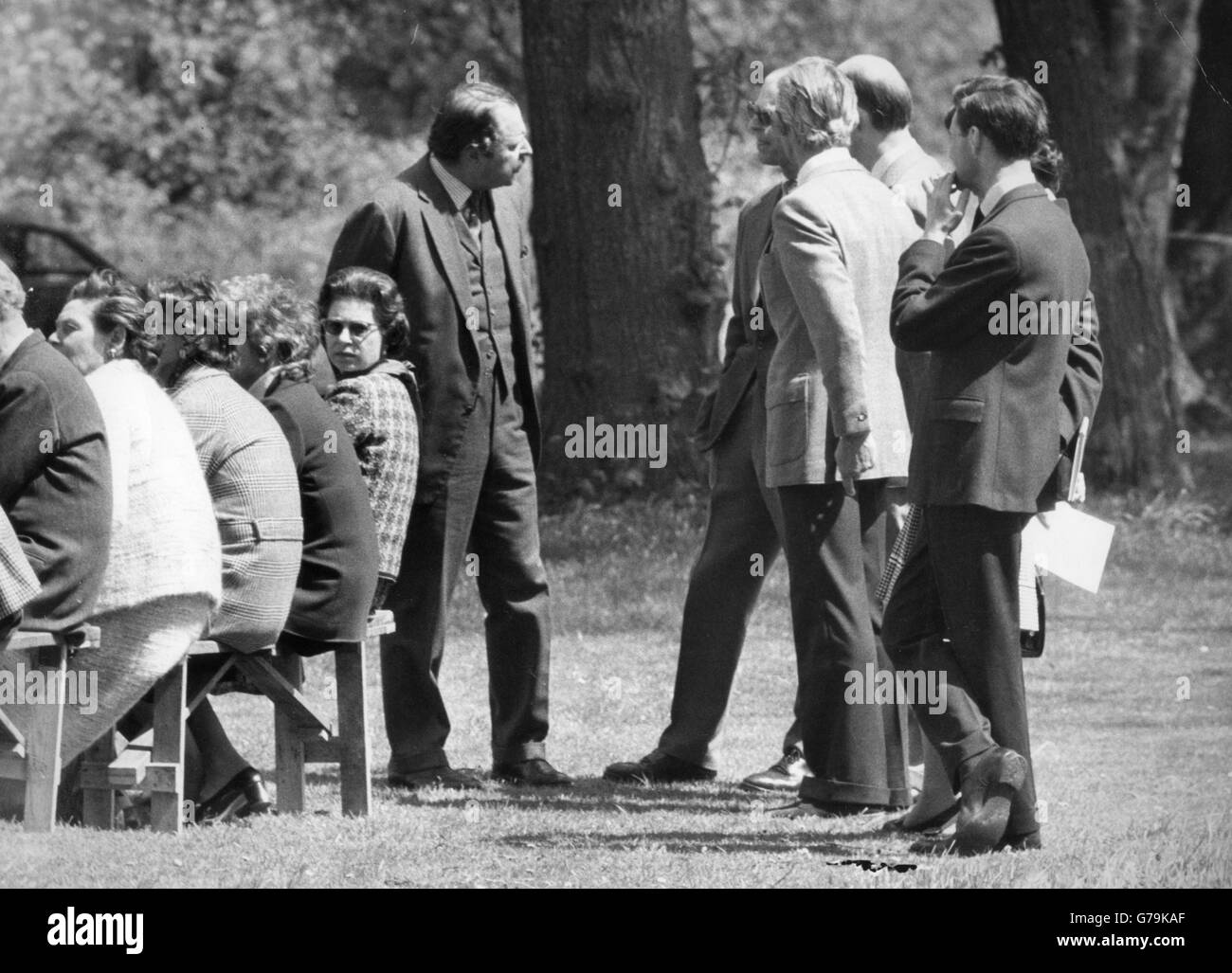 Queen Elizabeth II sits on a bench with other spectators at the Royal Horse Show at Windsor Castle. Stock Photo