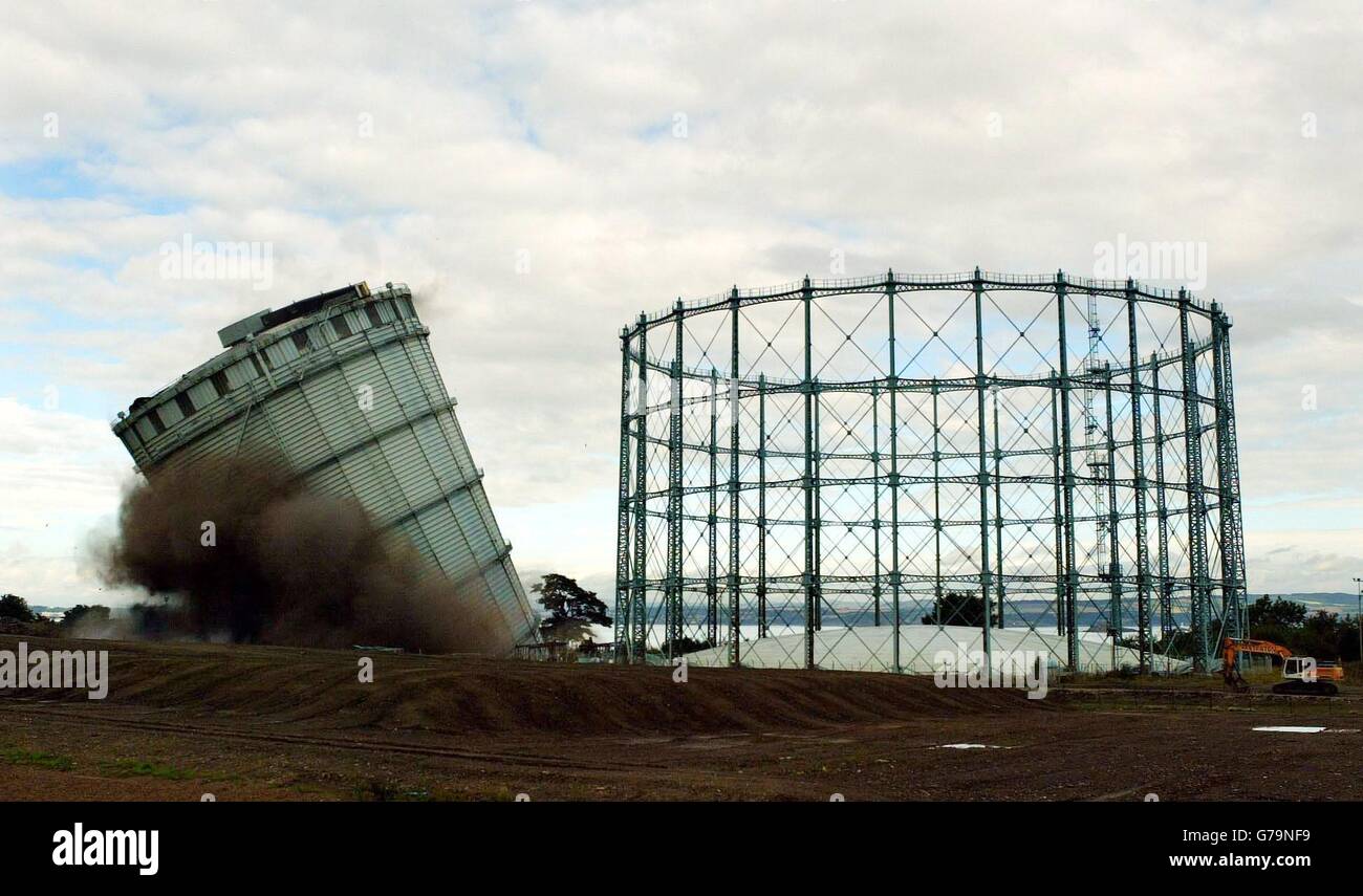 Third in a set of five photos. The 275ft gas holder (left) at the old Granton gasworks site in Edinburgh structures being demolished by a controlled explosion. The gas holder which was one of Edinburgh's tallest industrial structures has been demolished to make way for the redevelopment of the 110-acre site which is a key focus of the city's waterfront urban regeneration project. Stock Photo