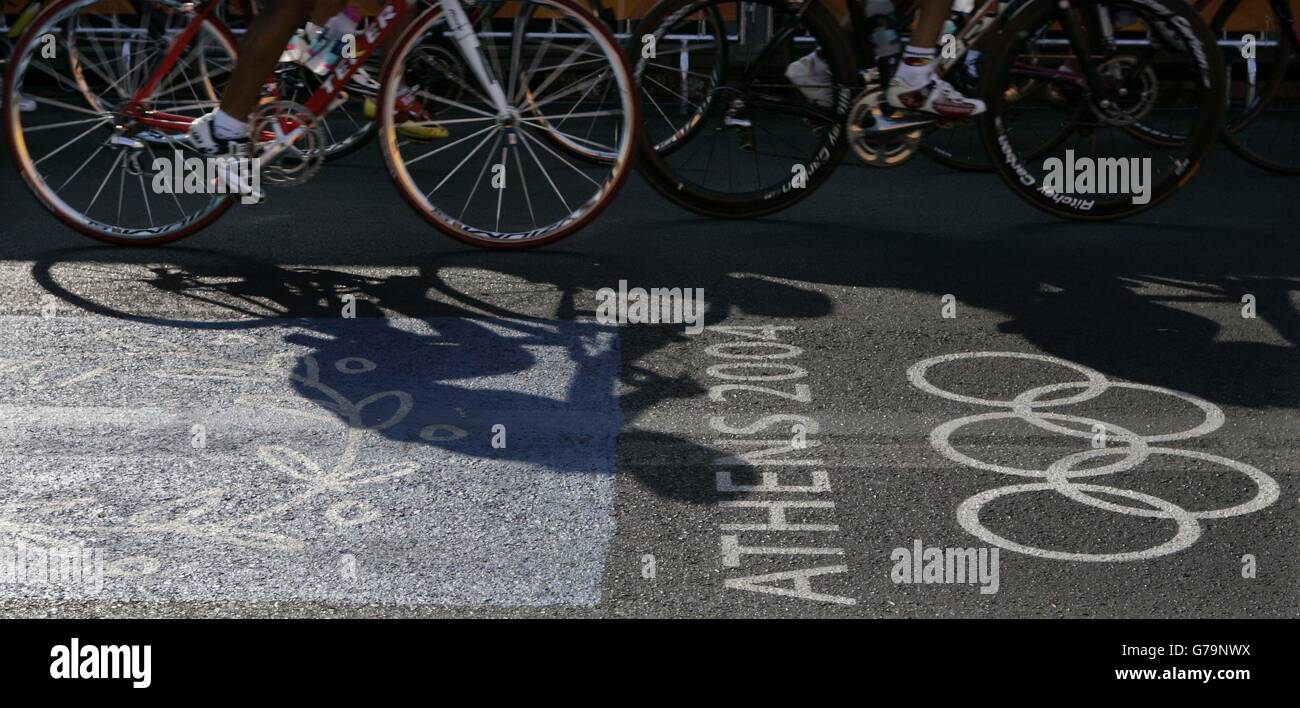 The Women's Cycling Road Race. Competitors in the Women's Cycling road race cast shadows across the Olympic Rings during the Olympic Games in Athens, Greece. Stock Photo