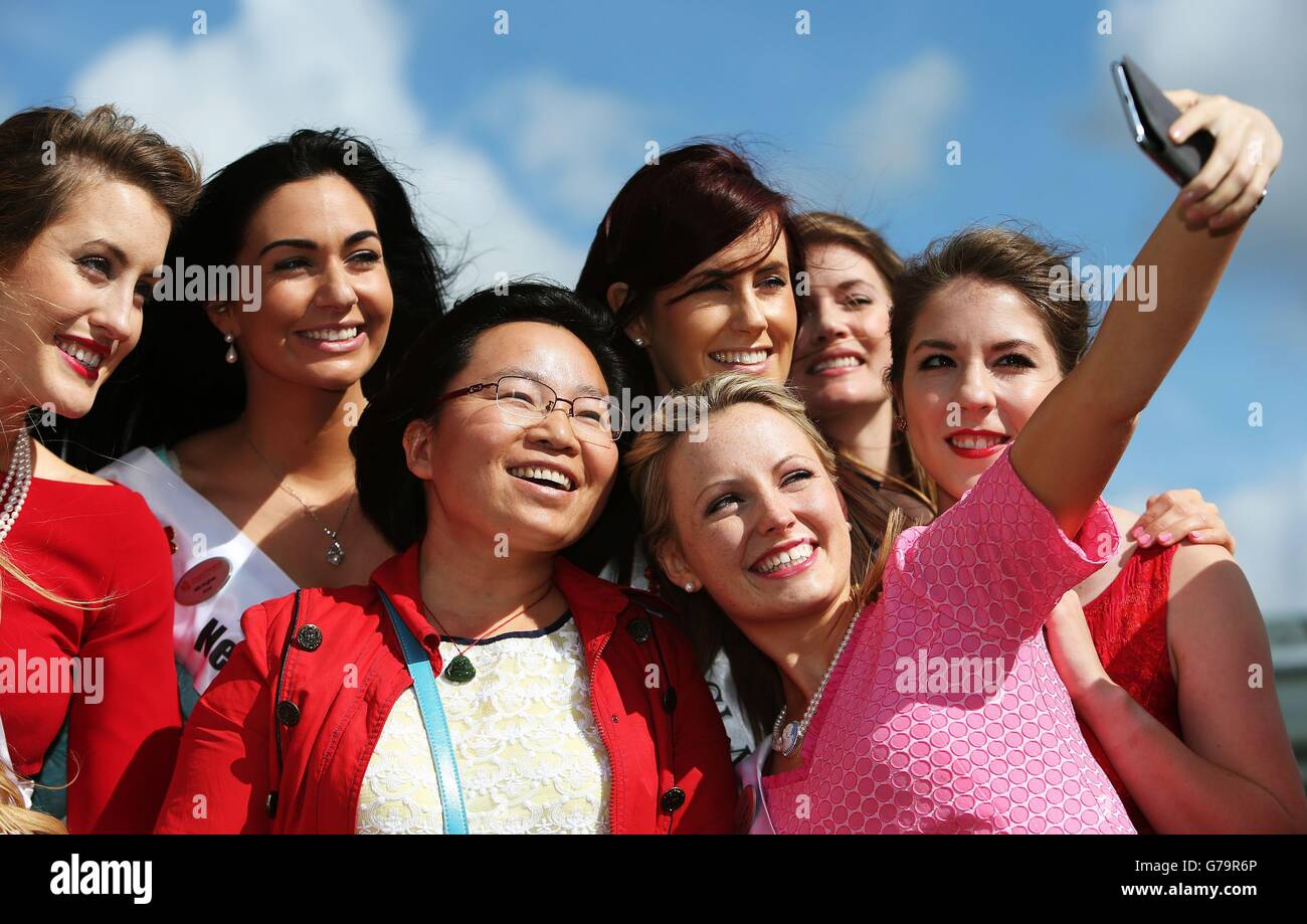 A Chinese tourist poses for a photo with some of the 32 Irish and International Roses taking part in the 2014 International Rose Selection at the launch of this years Rose of Tralee Festival at Dublin Airport. Stock Photo