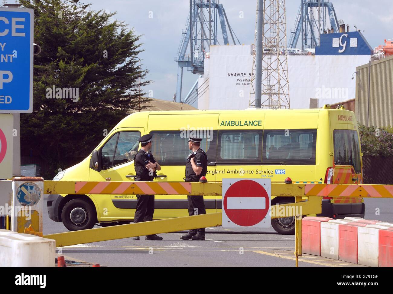 An ambulance van drives into Tilbury Docks in Essex, where a shipping container was found with illegal immigrants inside with one dead and the rest ill and taken to hospital. Stock Photo