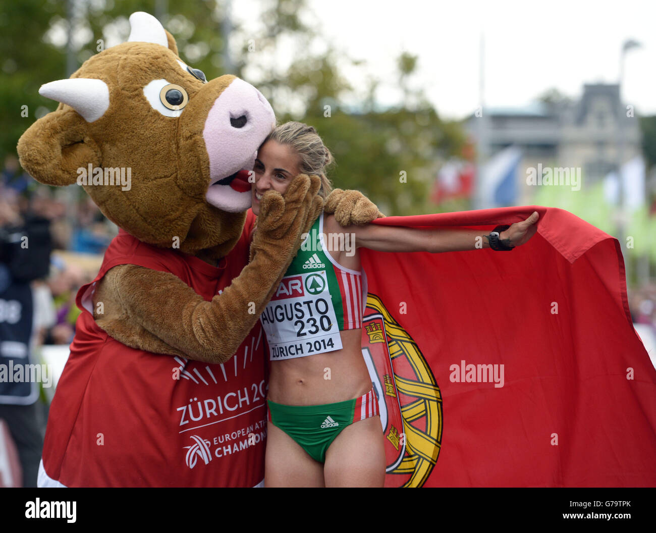 Portugal's Jessica Augusto gets a hug from the mascot 'Cooly' after finishing third in the Women's Marathon during day five of the 2014 European Athletics Championships at the Letzigrund Stadium, Zurich. Stock Photo