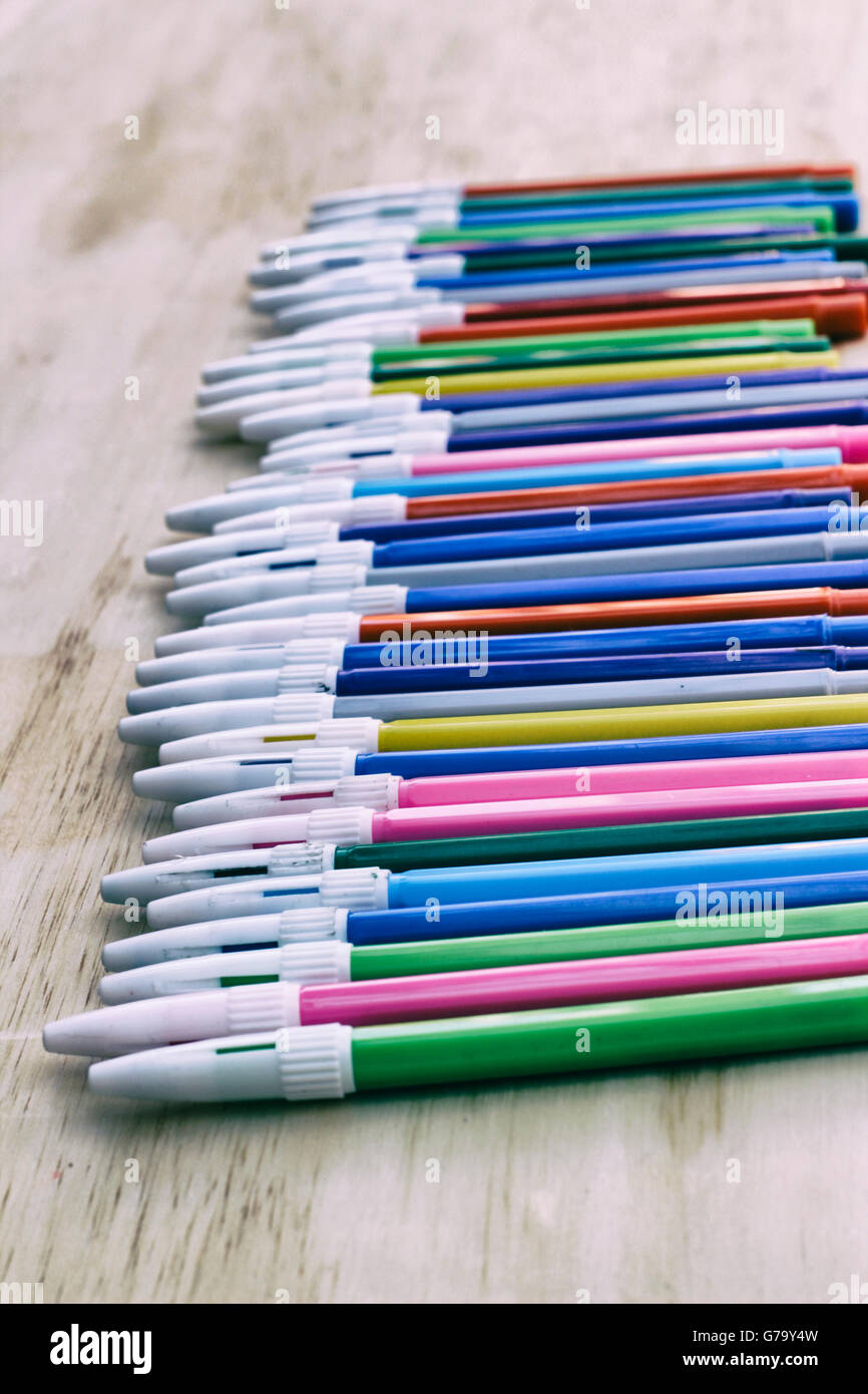 Photograph of some plastic colorful markers on a wood table Stock Photo