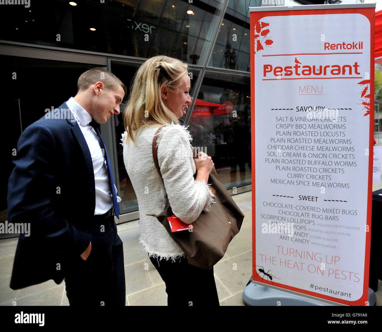 Members of the public look at Rentokil's Pop-up Pestaurant menu at One New Change, central London. Stock Photo