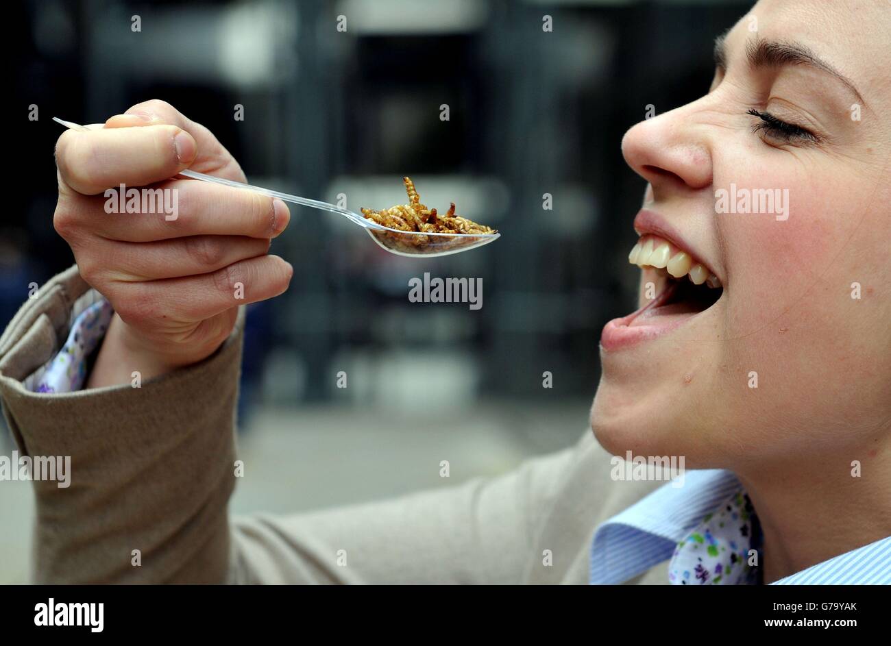 Julia Avdiu tries a spoonful of plain roasted meal worms at Rentokil's Pop-up Pestaurant at One New Change, central London. Stock Photo