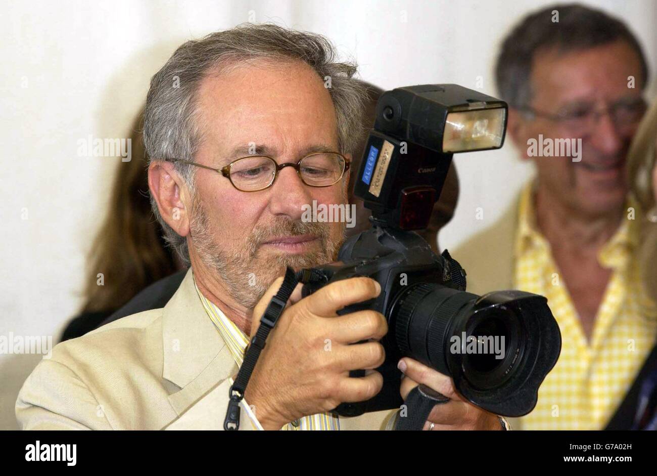 Director Steven Spielberg examines a photographers camera during a photocall at the Lido in Venice to promote his new film Terminal during the 61st International Venice Film Festival. Stock Photo