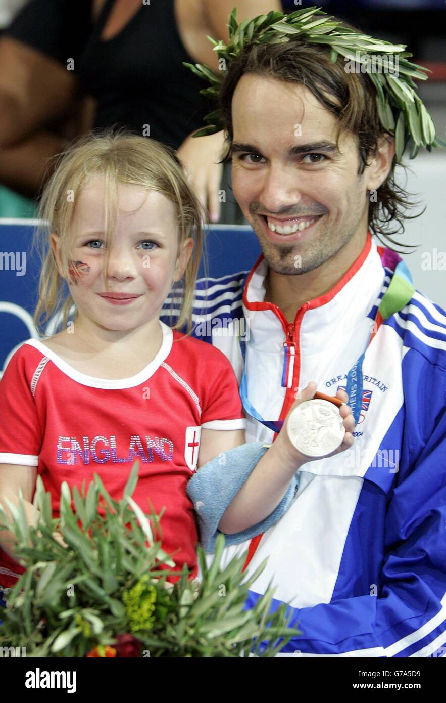 British badminton Silver Medal winner Nathan Robertson with his daughter Neve following his Gold Medal Mixed Doubles match with partner Gail Emms at the Goudi Olympic Hall in Athens, Greece. Emms and Robertson lost to China's Jun Zhang and Ling Gao 1-15 15-12 12-15. Stock Photo