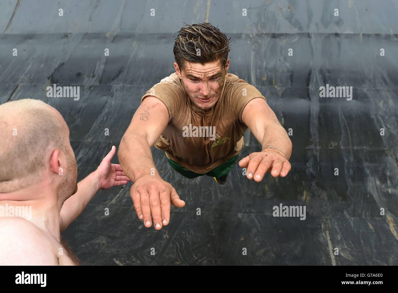 Competitors take part in Tough Mudder South West at Cirencester Park, Cirencester. Stock Photo