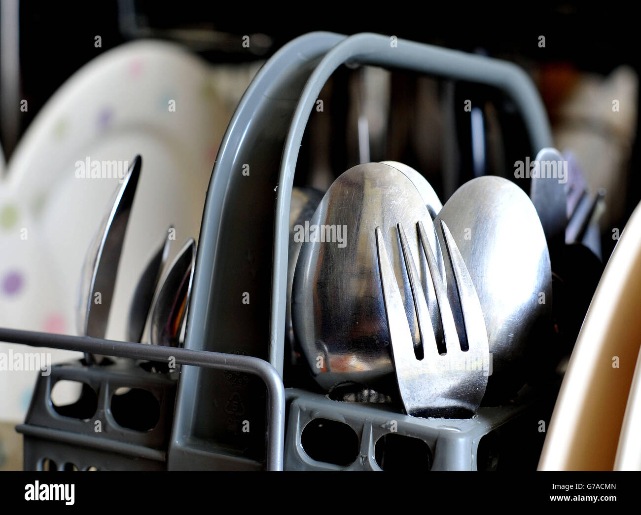 Dishwasher stock. Dirty crockery and eating utensils in a dishwasher