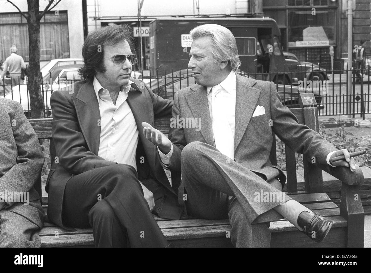 Sharing a London park bench are American singer-songwriter Neil Diamond (l) and Lord Delfont, who has clinched a deal for Diamond to star in his first feature film, The Jazz Singer, which is to be made by EMI of which Lord Delfont is chief executive. The Jazz Singer is a $10m contemporary version of the Al Jolson original. Stock Photo