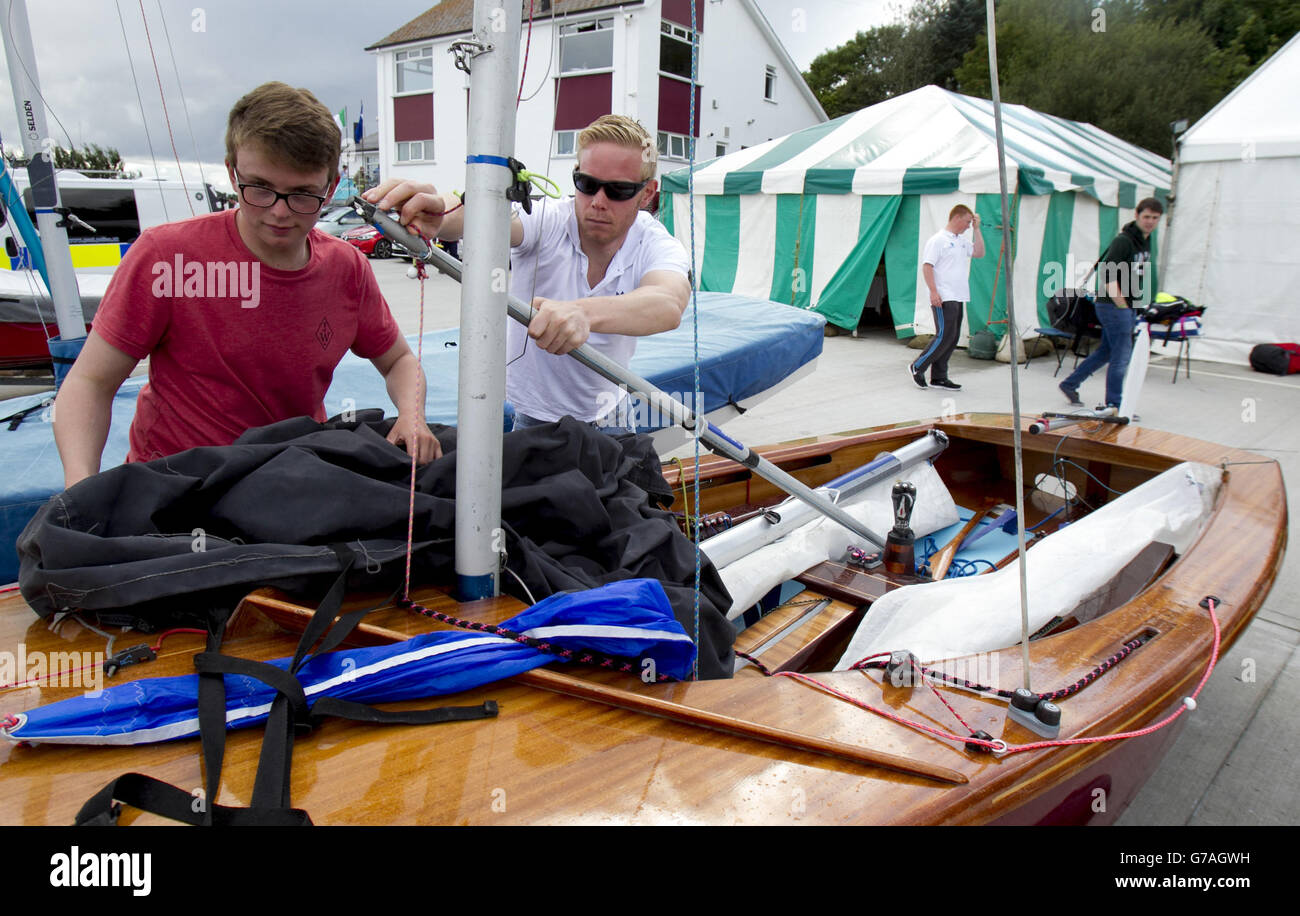 Jamie Ritchie (right) from Bangor and Charlie Edgar, 16, cover up a dinghy at the East Down Yacht Club, Killyleagh, Northern Ireland. Stock Photo