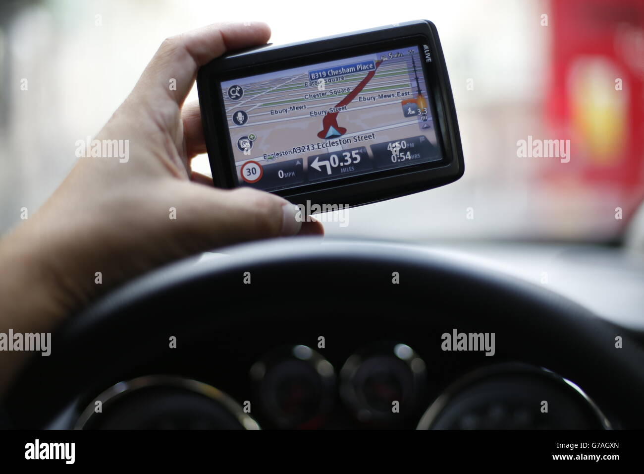 A man uses a satellite Navigator in his car. The sat nav system s a system of satellites that provide autonomous geo-spatial positioning with global coverage. It allows small electronic receivers to determine their location (longitude, latitude, and altitude ) to high precision (within a few metres) using time signals transmitted along a line of sight by radio from satellites. Stock Photo