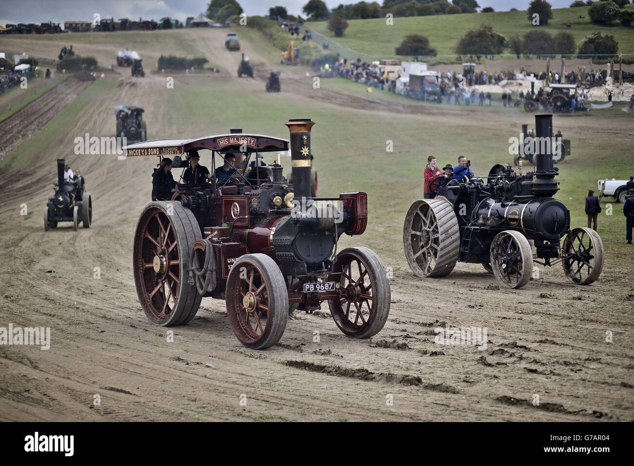 Traction engines make their way around the main arena at the Great Dorset Steam Fair, where hundreds of period steam traction engines and heavy mechanical equipment from all eras gather for the annual show. Stock Photo