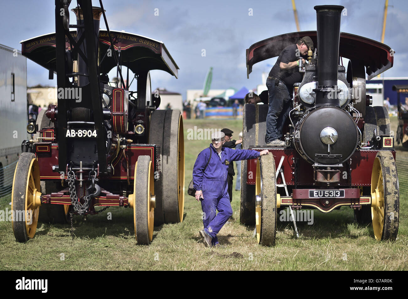 Traction engine crews tinker in preparation for parading in the main arena at the Great Dorset Steam Fair, where hundreds of period steam traction engines and heavy mechanical equipment from all eras gather for the annual show. Stock Photo