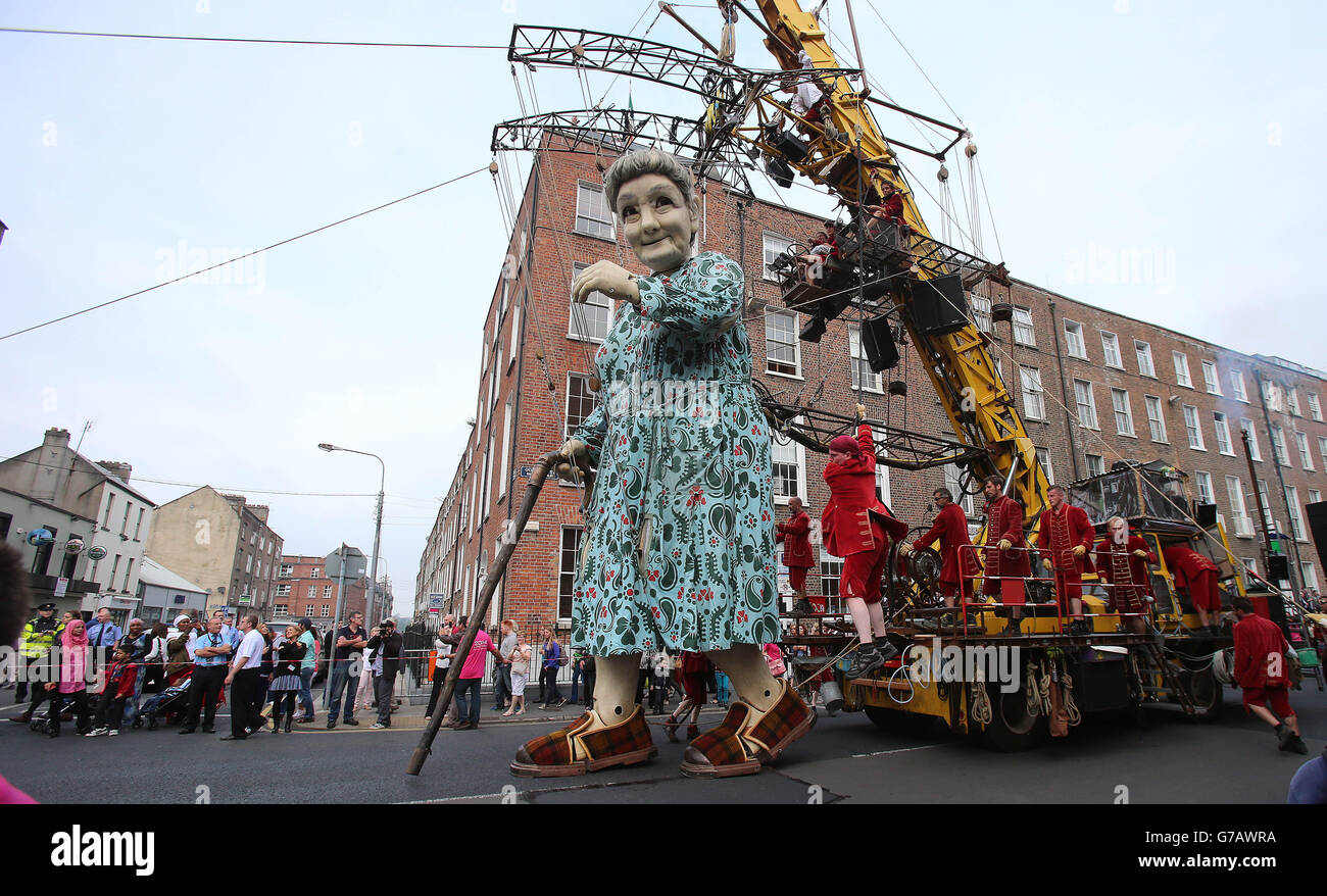 Crowds watch as performers from the French arts group Royal de Luxe take to the streets of Limerick with their giant grandmother parade as part of this years city of culture celebrations. Stock Photo