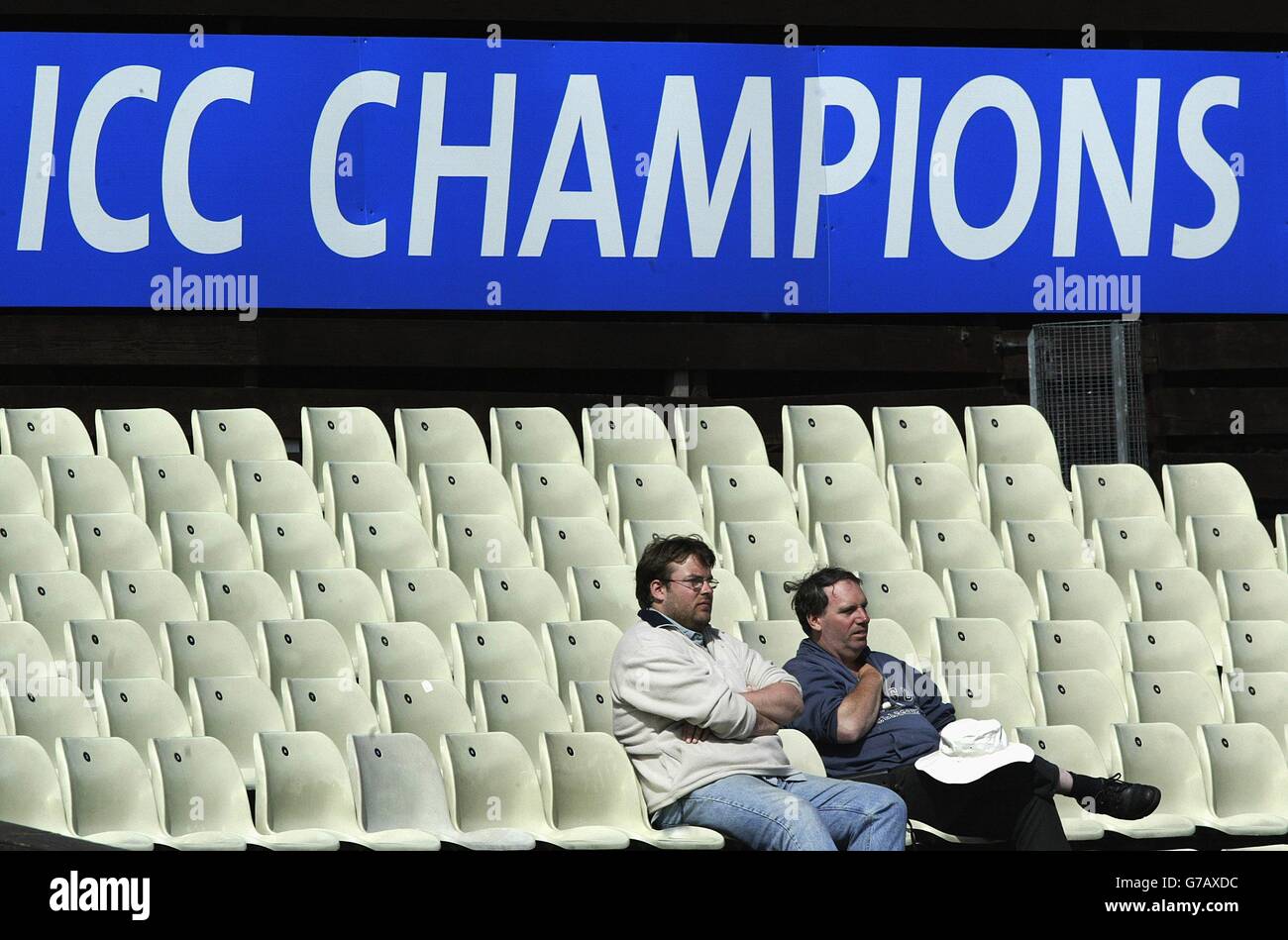 Two cricket fans surrounded by empty seating watch England's victory over Zimbabwe at Edgbaston during their ICC Champions Trophy match at Edgbaston, Birmingham. Stock Photo