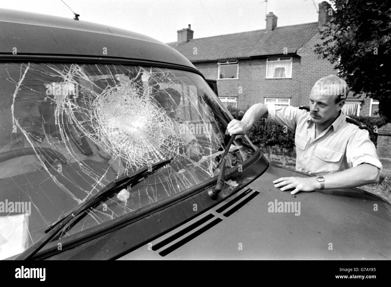 A policeman inspects the smashed window of a transit van after violence at the Markham Main NCB Colliery at Armthorpe, near Doncaster, Yorkshire. Stock Photo