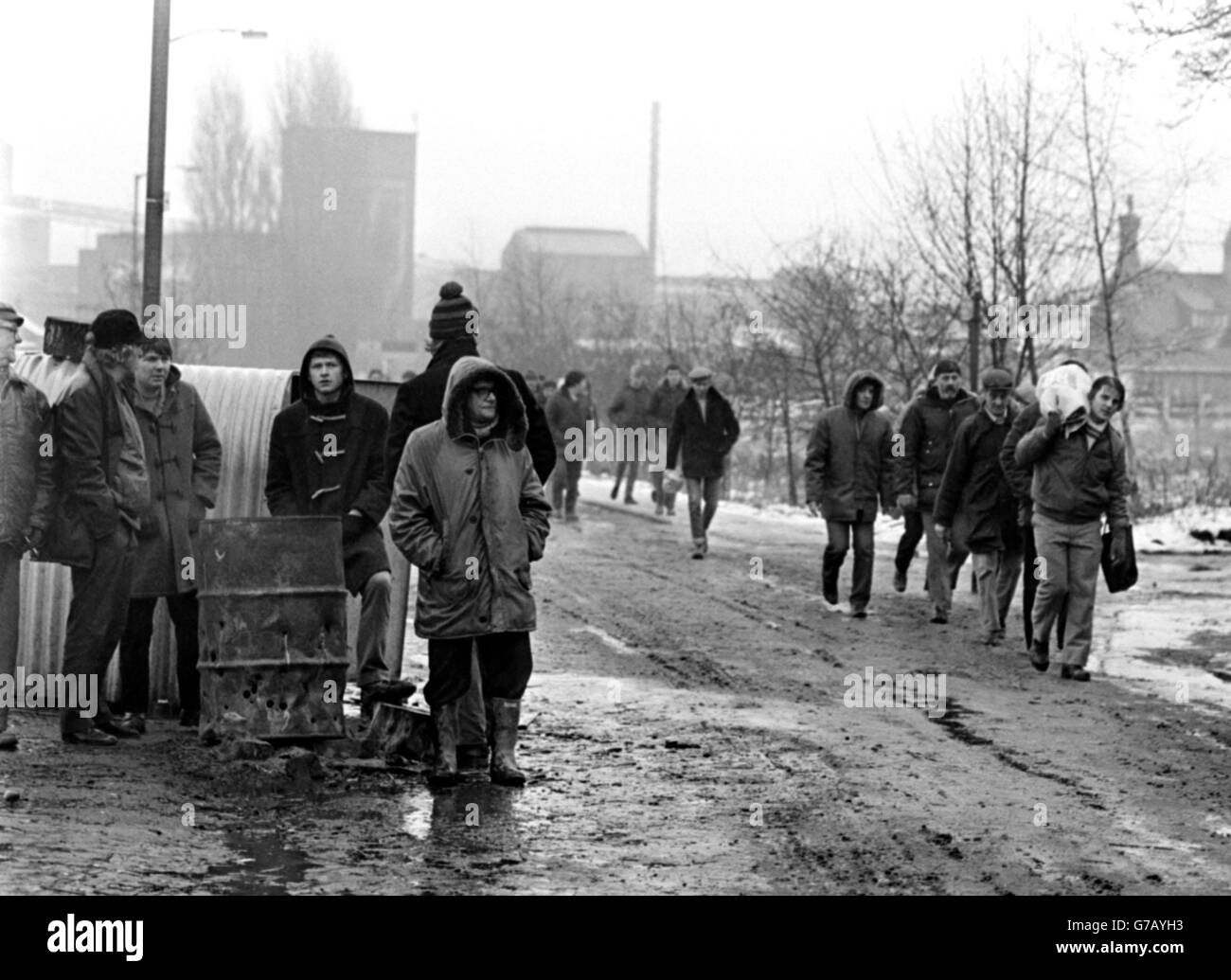 Men who have returned to work at Kiveton park Colliery walk past pickets at lunchtime after completing their shift. The National Coal Board said 150 men clocked on for the first time today, bringing the total at work at the pit to 361 - 50% of the workforce. The figures are disputed by the NUM branch president. Stock Photo