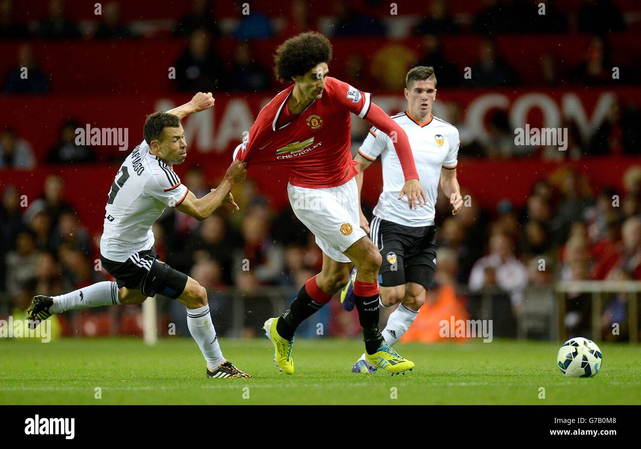 Manchester United's Marouane Fellaini battles for the ball with Valencia's Javi Fuego, during a pre season friendly at Old Trafford, Manchester. Stock Photo