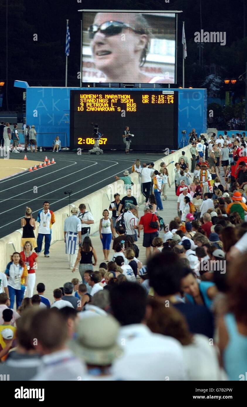 The crowd in the Panathinaiko Stadium watch on a big screen as Great Britain's Paula Radcliffe pulls out of the Marathon during the Olympic Games in Athens, Greece. Stock Photo