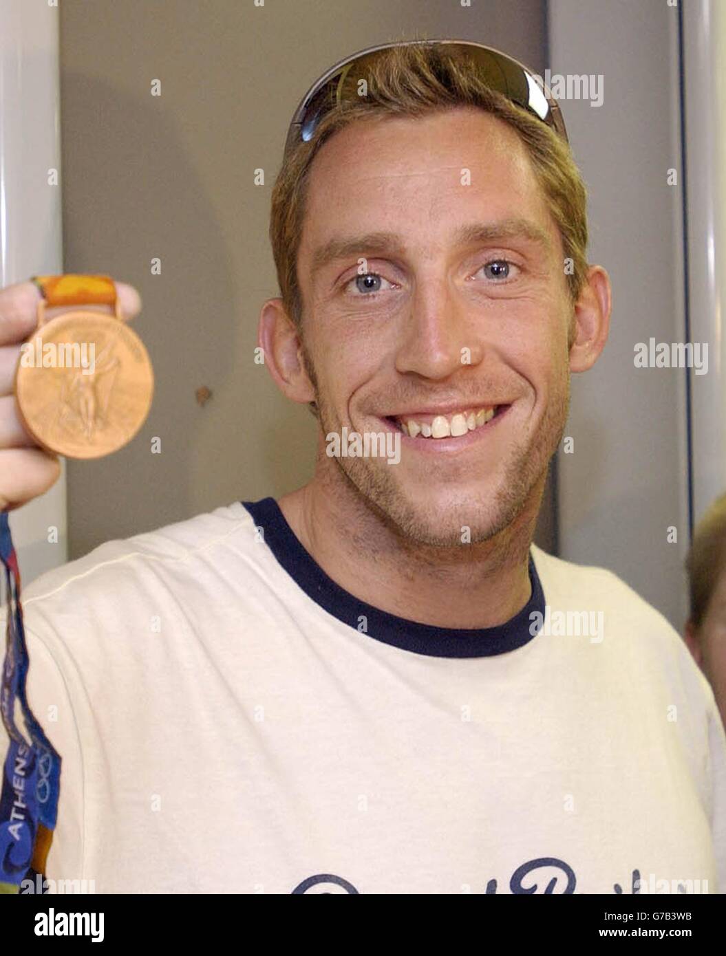 British Olympic swimmer Stephen Parry shows off his bronze medal won in the men's 200m butterfly, as he arrives home from the Athens games at Manchester Airport. Stock Photo