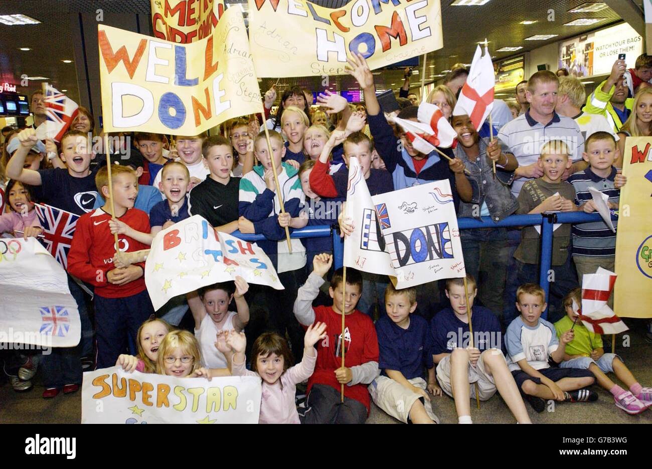Olympic swimmers return home. Supporters welcome back British Olympic swimmers returning from the Athens games at Manchester Airport. Stock Photo