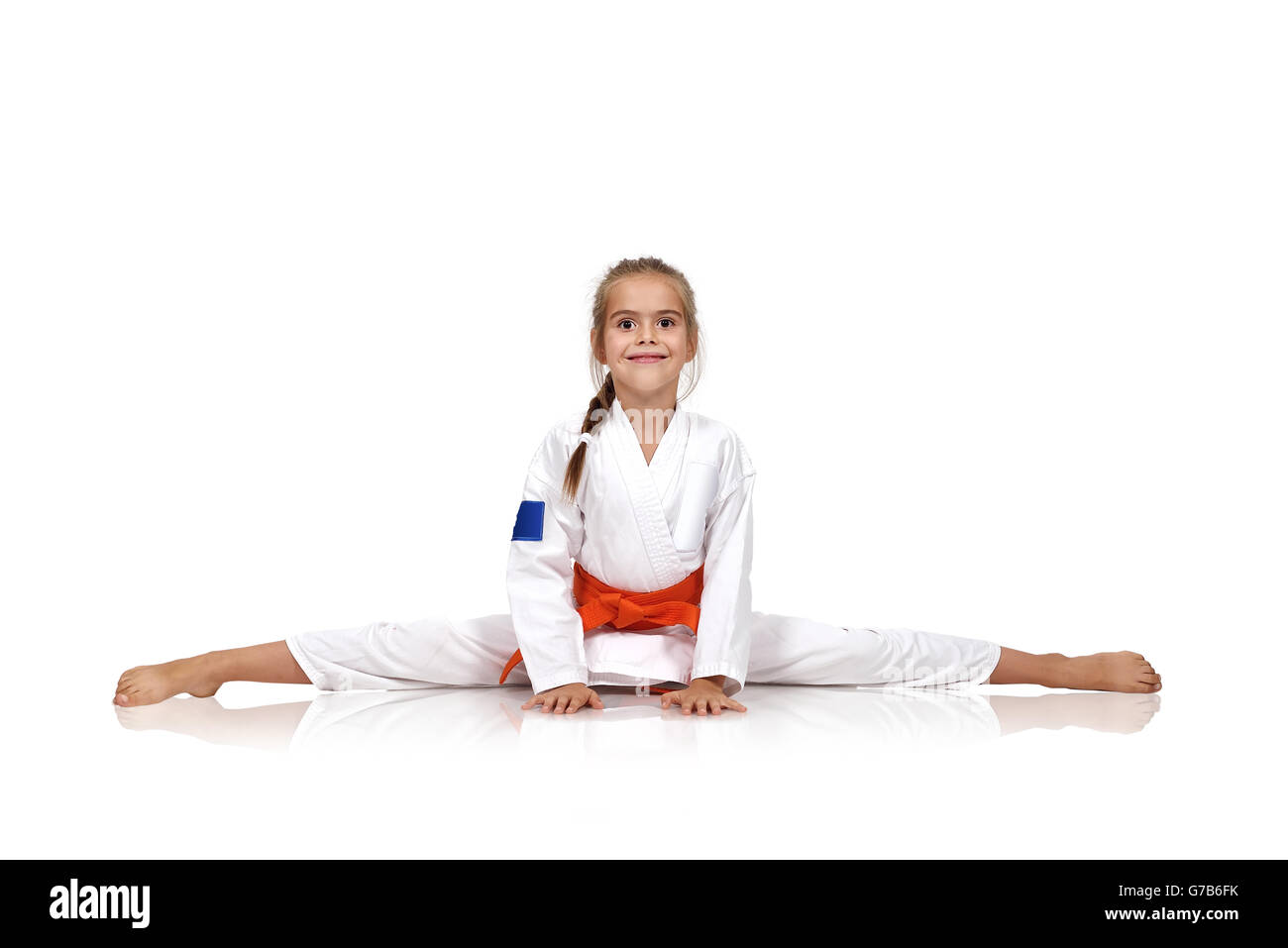 karate girl sitting on the splits Stock Photo