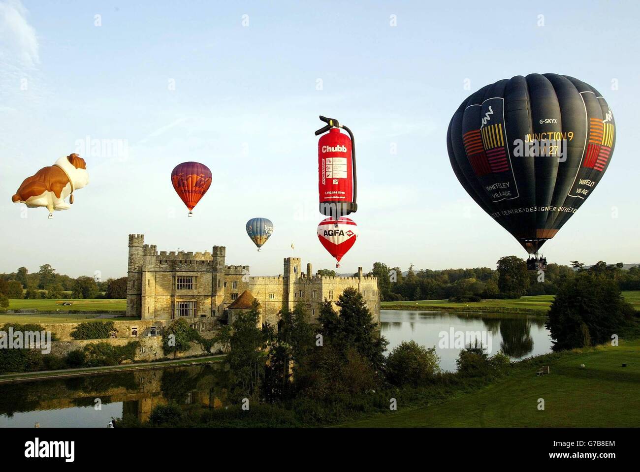 Hot air balloons emerge above Leeds Castle in Kent as the castle prepares to host its annual Hot Air Balloon and Vintage Car Festival this weekend. Stock Photo