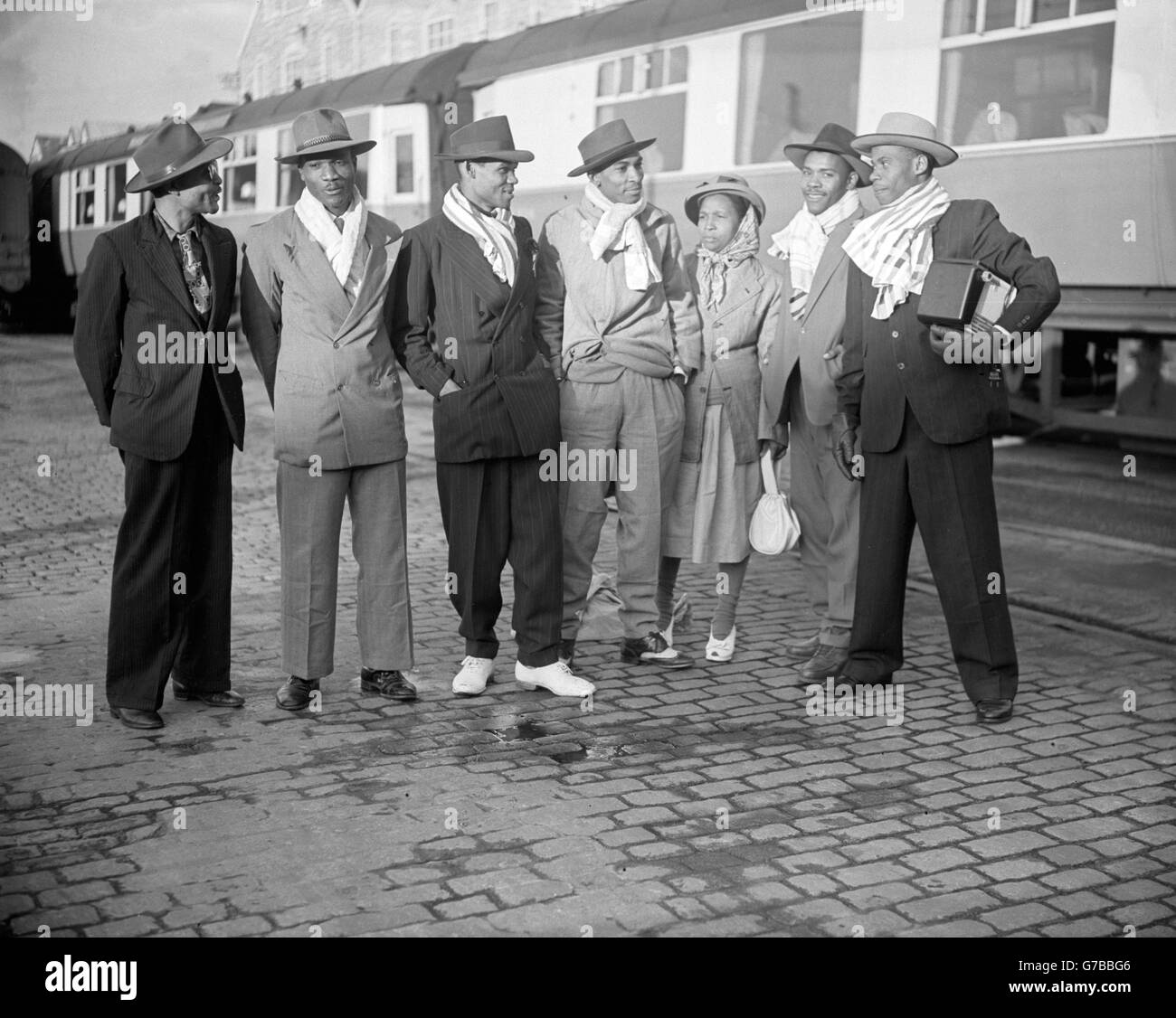 Two hundred men and women arriving at Plymouth in the French liner 'Colombie' from the West Indies. They were greeted by a bleak, cold January day, and to help protect against the cold they used bath towels as head scarves. Stock Photo