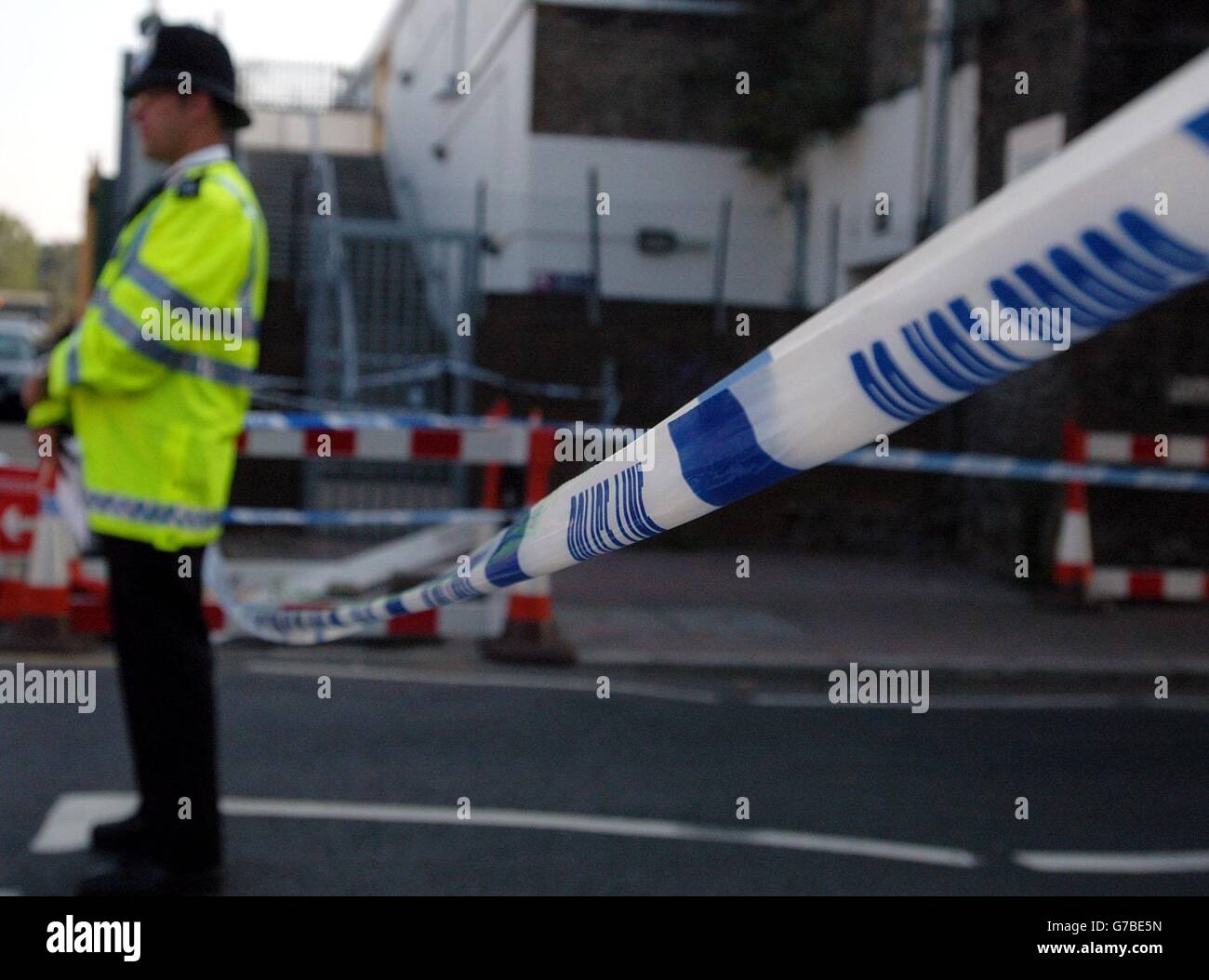A police officer re-directs early morning commuters who arrived at Wood Street Train Station in East London to find the station closed after a man was stabbed during the early hours of the morning. Stock Photo