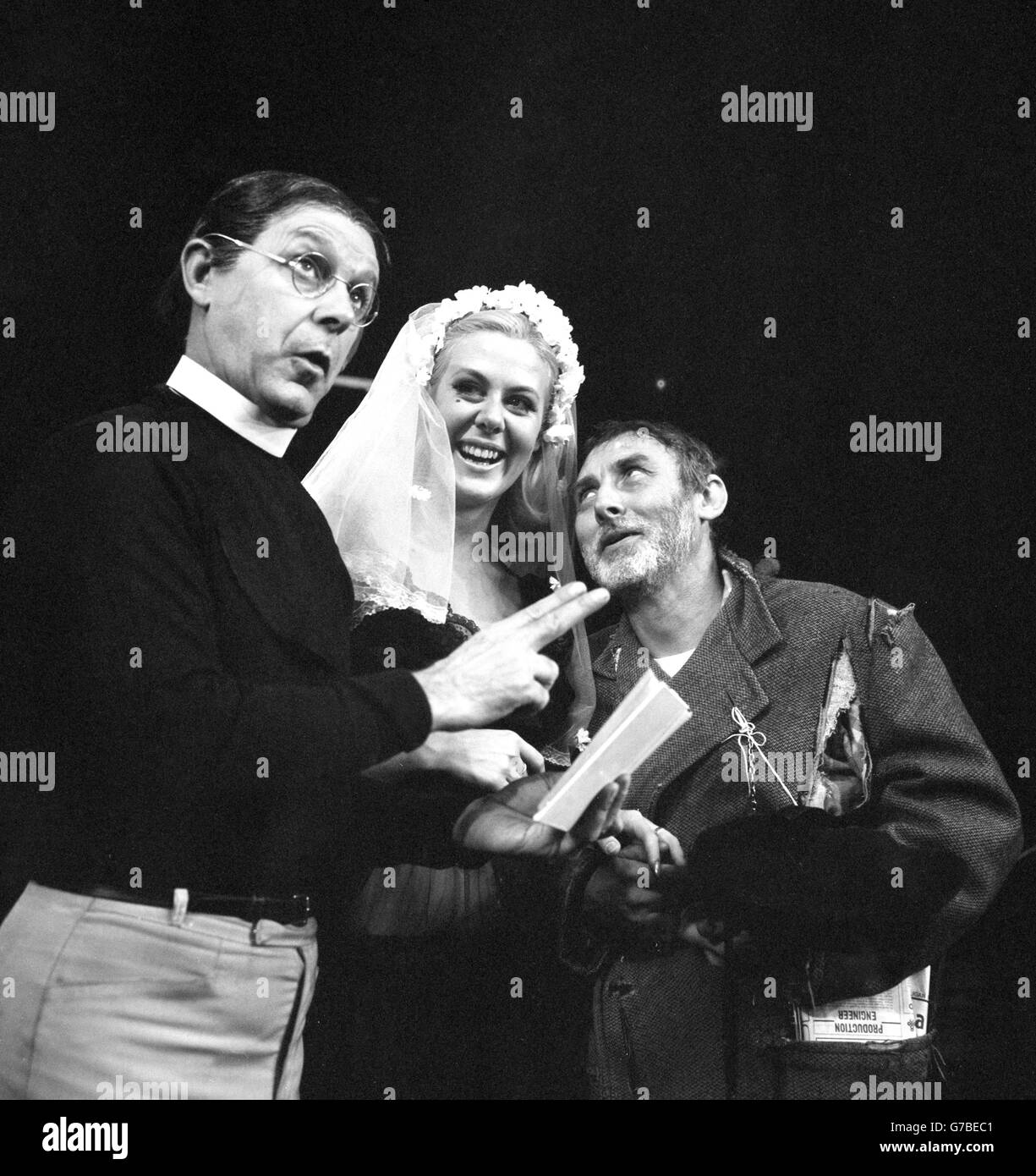 (l-r) Bill Kerr, Valerie Van Ost and Spike Milligan perform a scene from The Bed-Sitting Room, a comedy written by Milligan and John Antrobus, which is due to open at the Mermaid Theatre in London. Stock Photo
