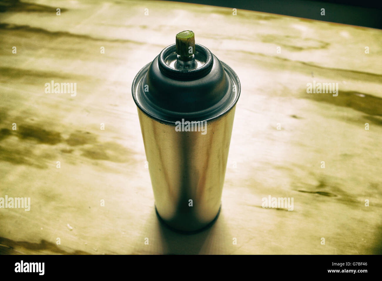 Photograph of a spray paint can on a wood table Stock Photo