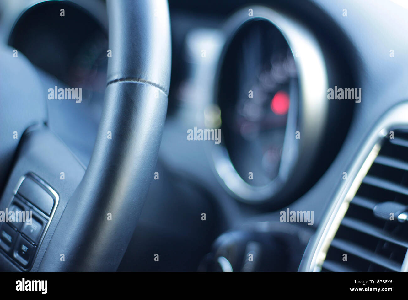 Photograph of a Car steering wheel and instrument cluster Stock Photo