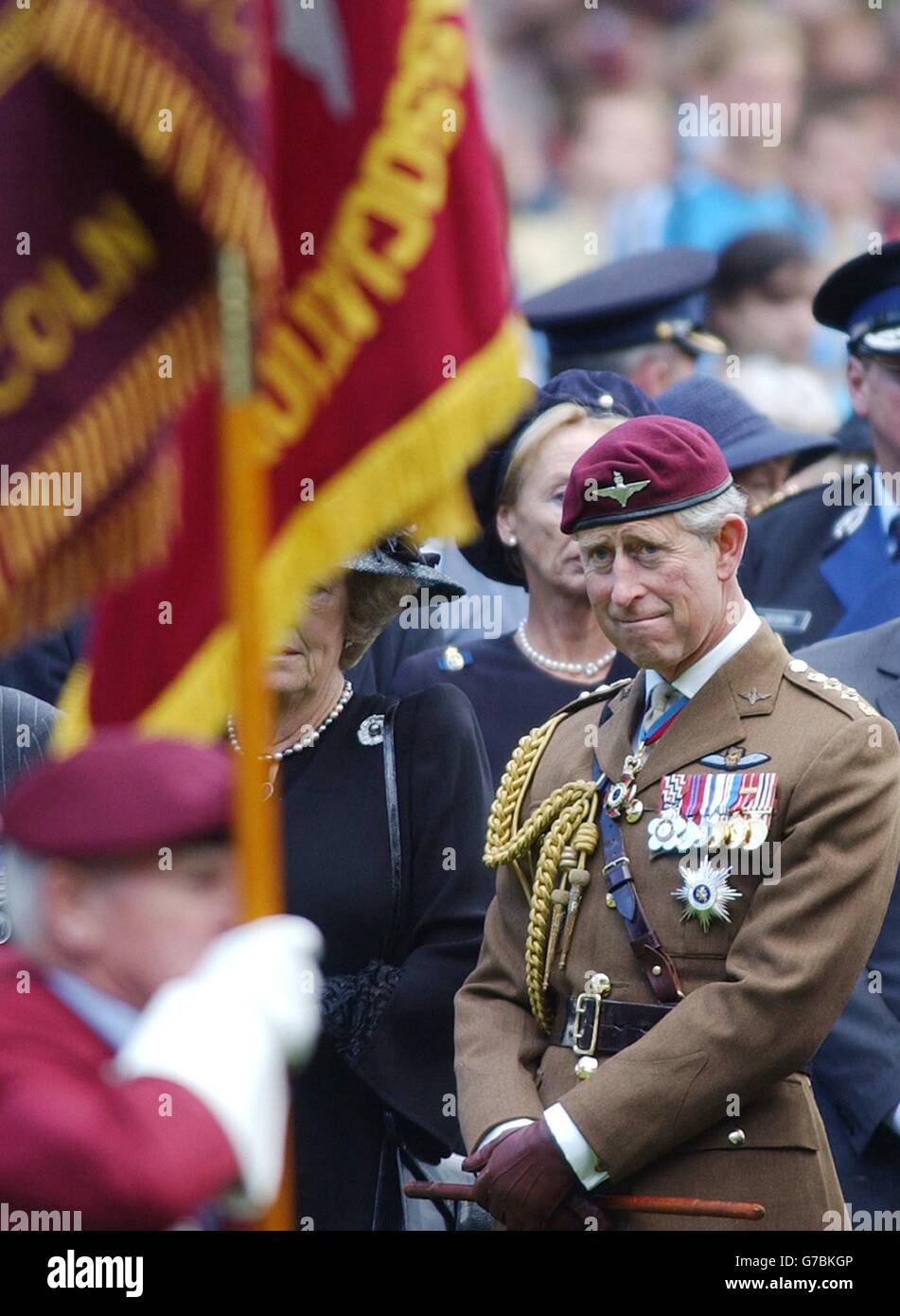The Prince of Wales watches as veteran standard bearers pass him at the 60th Anniversary Pilgrimage Airborne Memorial Service at Oosterbeek War Cemetery, near Arnhem, Holland. Prince Charles joined more than 5,000 veterans and their families to remember those killed in the epic Battle of Arnhem exactly 60 years ago. Sunday September 19, 2004. See PA story ROYAL Arnhem. PA Photo: Kirsty Wigglesworth. Stock Photo