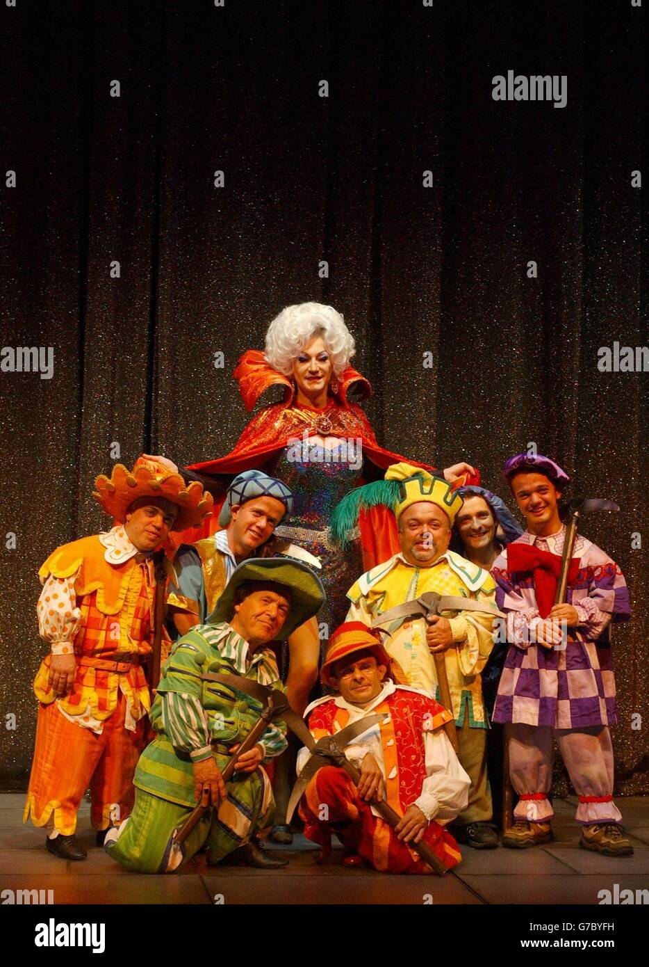 Lily Savage as the Wicked Queen with the seven dwarfs pose for photographers on stage during a photocall for Snow White and the Seven Dwarfs at the Victoria Palace Theatre in London. The family pantomime runs at the theatre for only 50 performances from Friday 17 December to Sunday 23 January 2005. Stock Photo