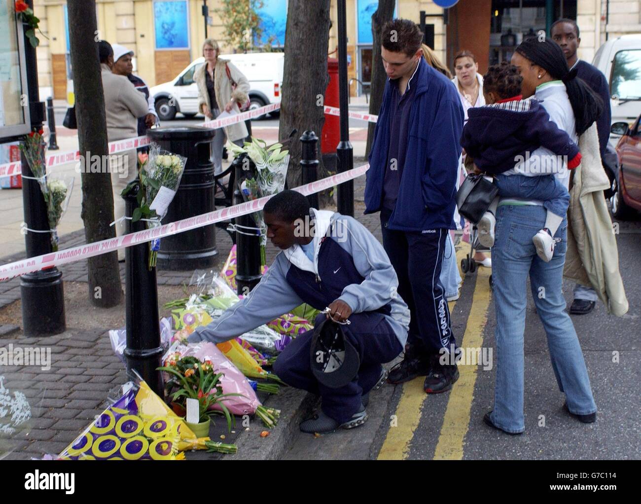 Former school mates (centre) of an as yet unnamed 16 year old schoolboy who was stabbed to death near Hackney Town Hall, London, gather near flowers. The boy was stabbed during the clash in east London, shortly before 4pm yesterday as school classes finished. Witnesses said they saw youngsters chasing each other along Mare Street before the fatal wounding. Stock Photo