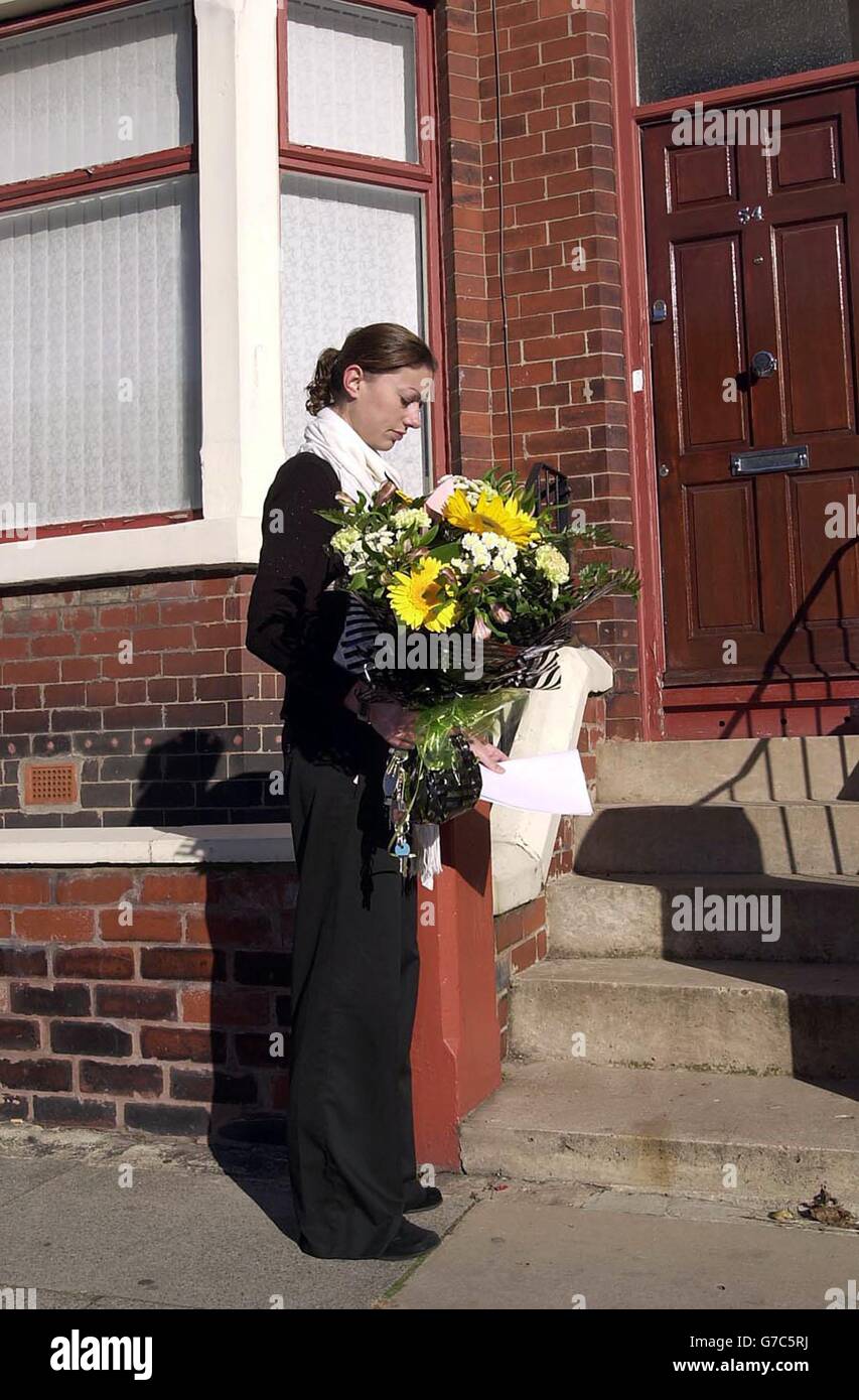 A reporter places flowers on the doorstep of the Bigley residence in