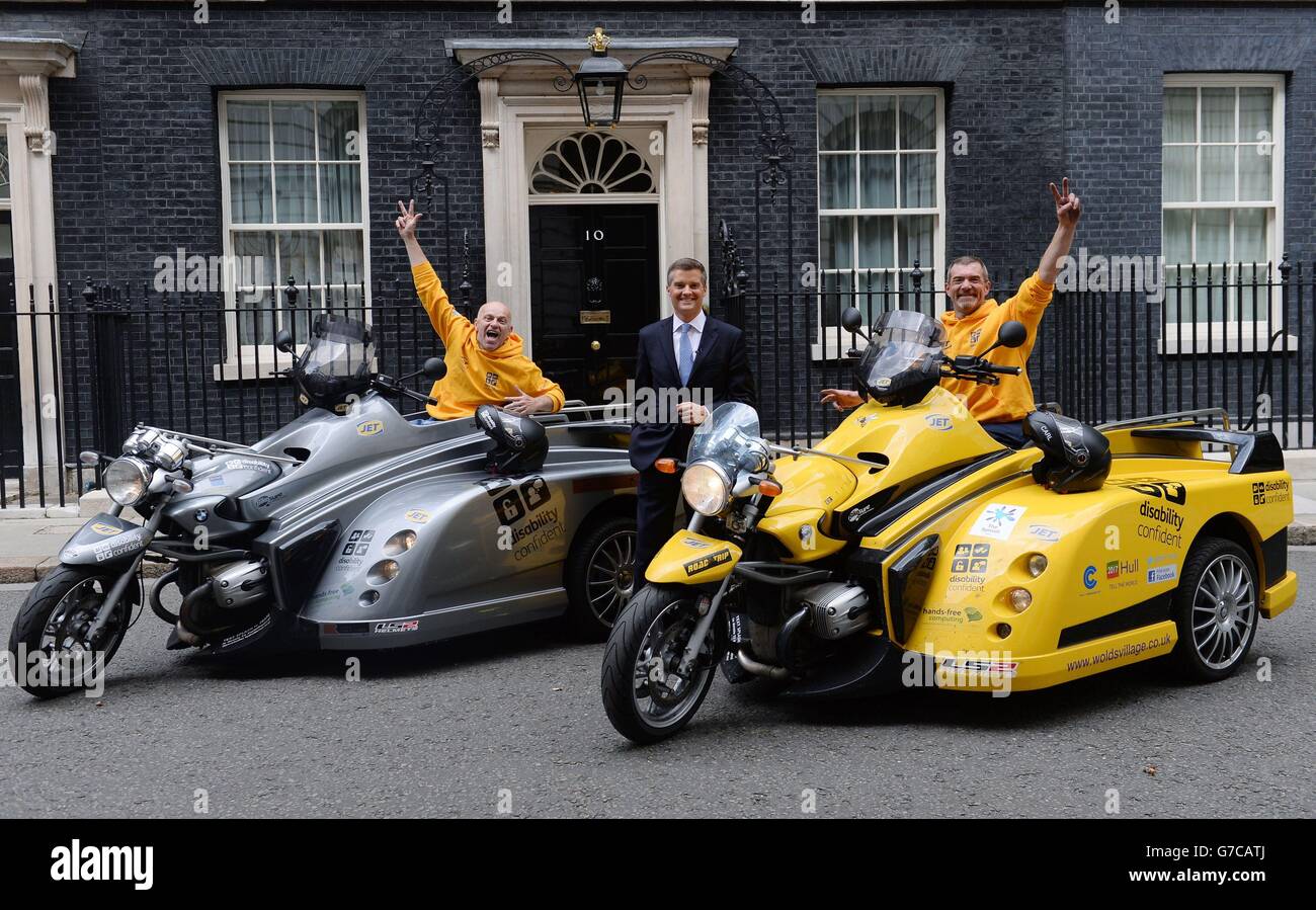 Wheelchair users David Burdus (left) and Carl Brunning arrive in Downing Street, London, meet Minister of State for Disabled People Mark Harper (centre) as they take part in a 2,200-mile round trip from John O'Groats to Land's End in wheelchair-driven motor trikes. Stock Photo