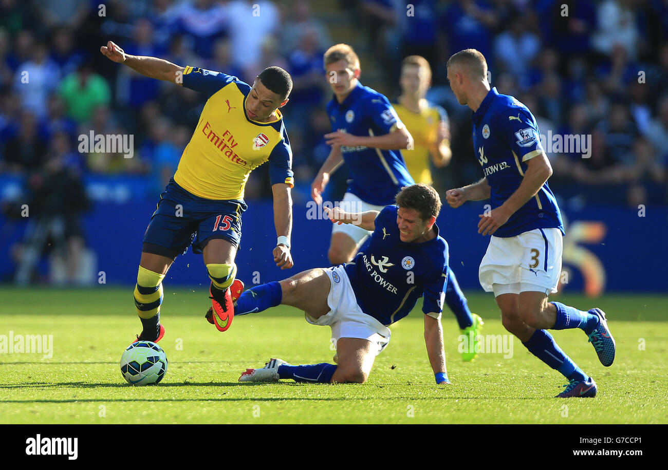 Arsenal's Alex Oxlade-Chamberlain breaks past tackle from Leicester City's Dean Hammond (centre) and runs at Leicester City's Paul Konchesky (right) Stock Photo