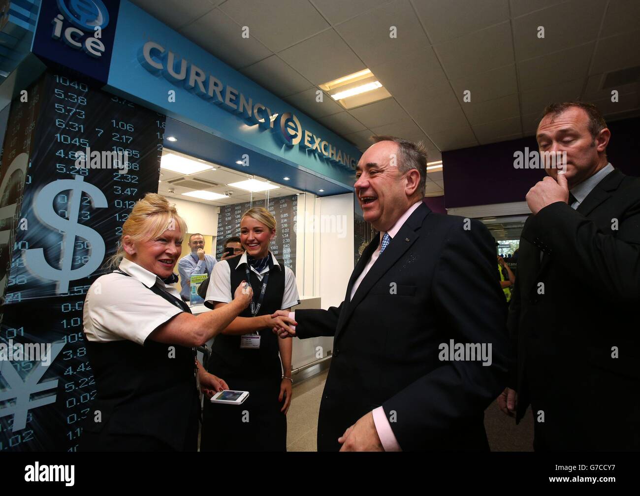 First Minister Alex Salmond speaks with staff outside the Currency Exchange as he arrrives at Edinburgh Airport to meet with Business leaders at a photocall ahead of the Scottish Referendum. Stock Photo