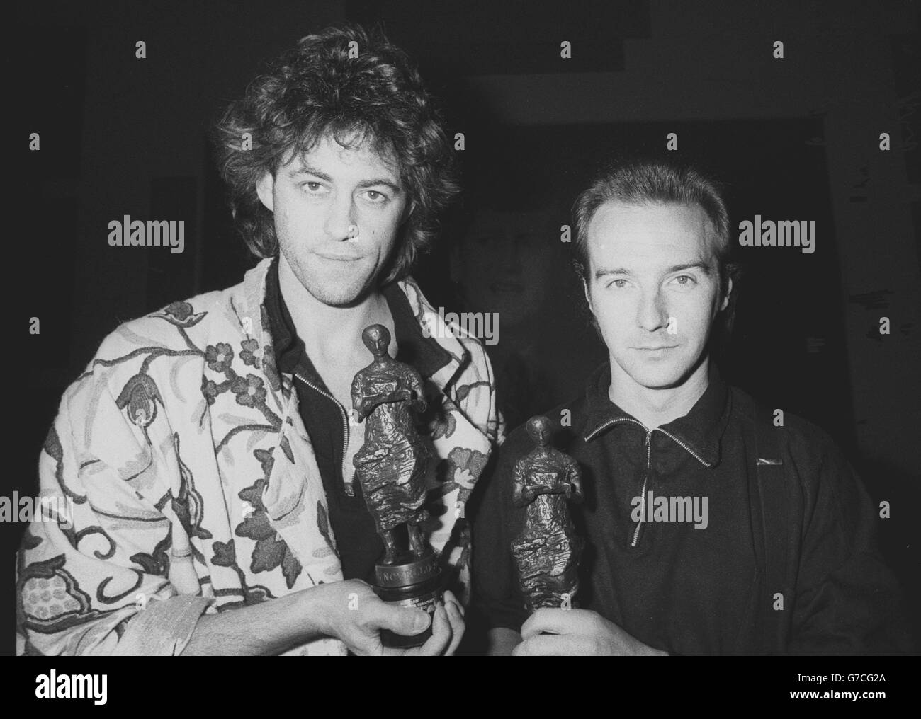 Midge Ure (R), 31, of the rock group Ultravox, with Bob Geldof at the Ivor Novello Awards for 1984 at the Grosvenor House Hotel, London. The pair won a joint award for the Band Aid single 'Do They Know It's Christmas?'. Stock Photo