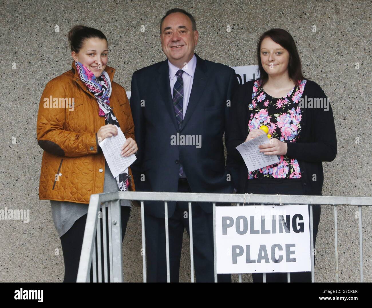 Scottish First Minister Alex Salmond with first time voters Lia Pirie (left) and Natasha McDonald (right) outside Ritchie Hall polling station in Strichen as polls have opened on a historic day for Scotland as voters determine whether the country should remain part of the United Kingdom. Stock Photo